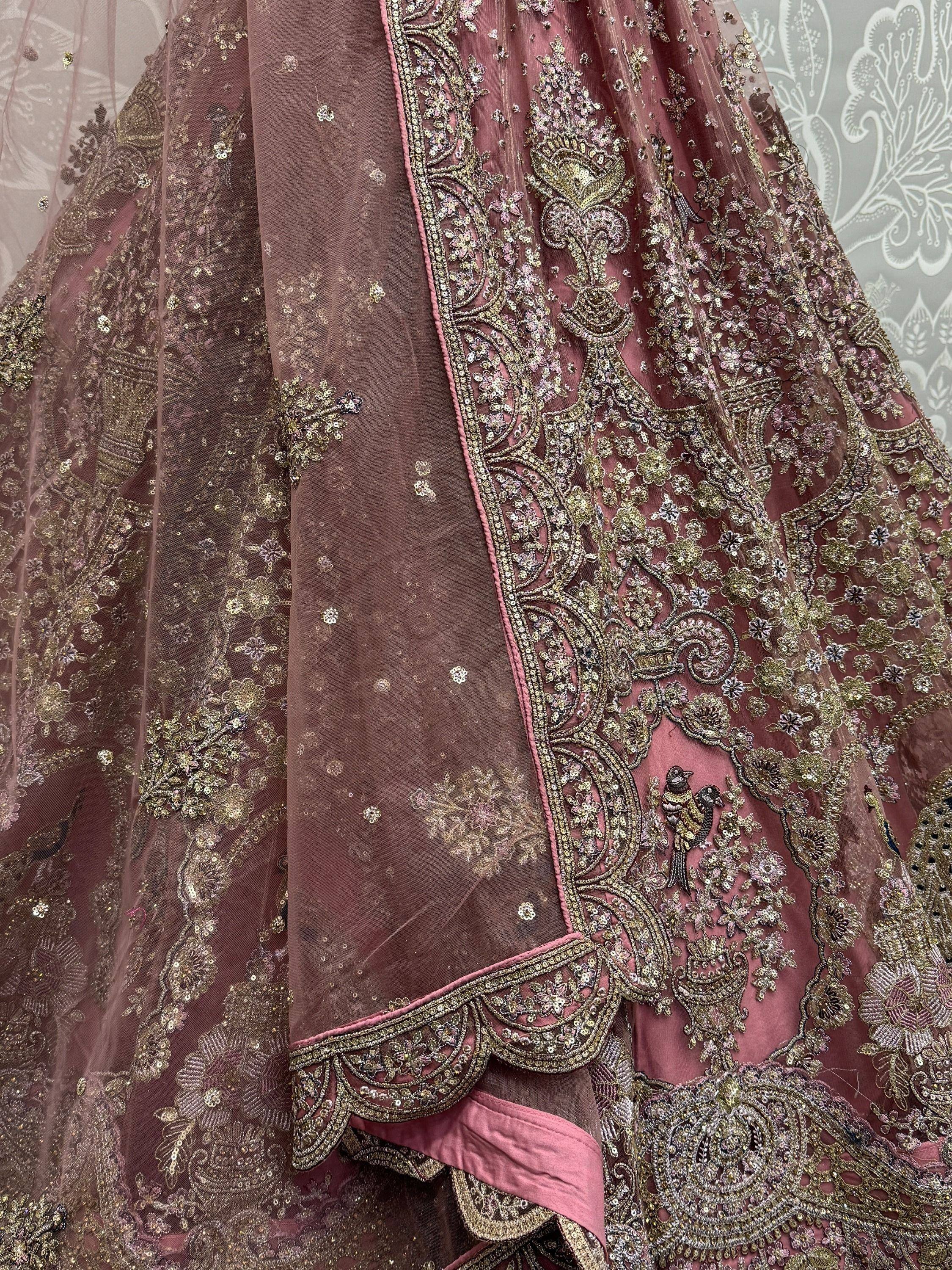 Dusty rose designer lehenga with intricate gold embroidery and floral motifs, perfect for Indian weddings.
