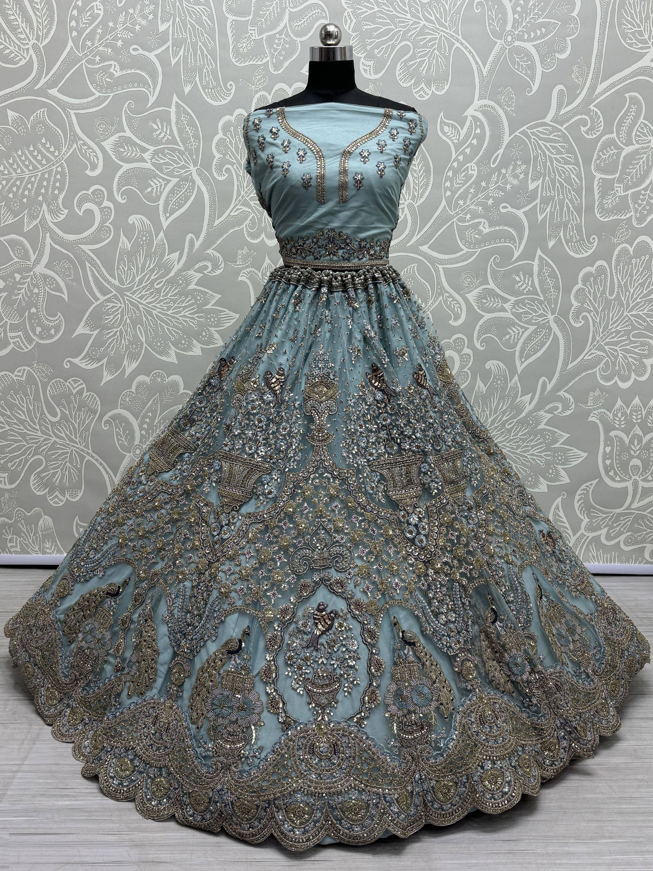 Dusty blue designer lehenga with intricate gold embroidery and peacock motifs, perfect for Indian weddings.
