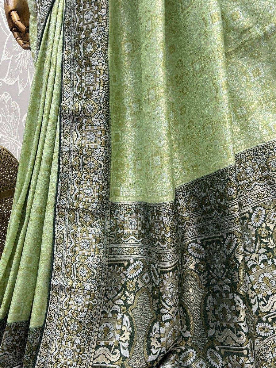 Light green designer saree with intricate gold and black border, perfect for ethnic wear occasions.