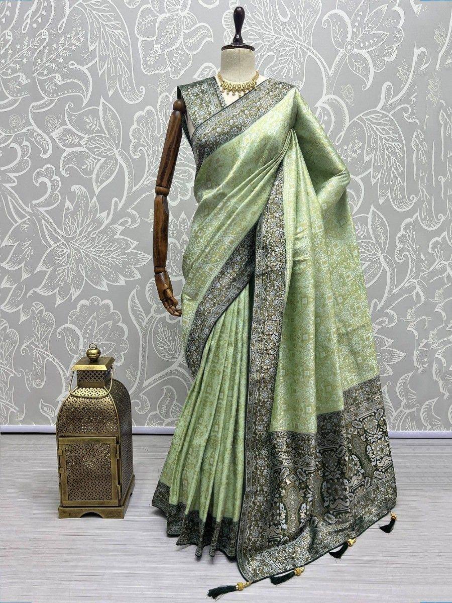 Mint green designer saree with intricate silver border, displayed on mannequin for ethnic wear