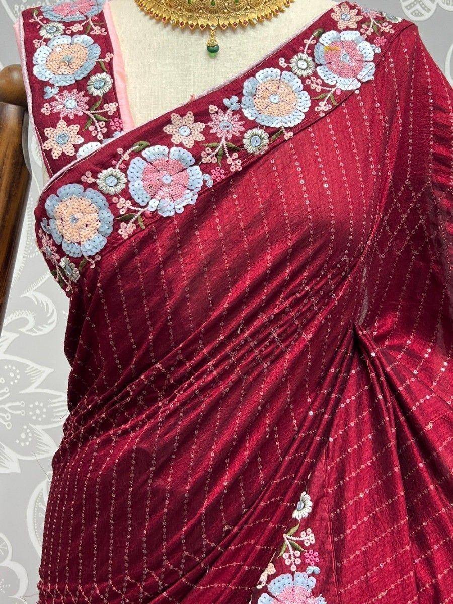 Maroon saree with floral embroidery and sequin detailing, styled with gold necklace