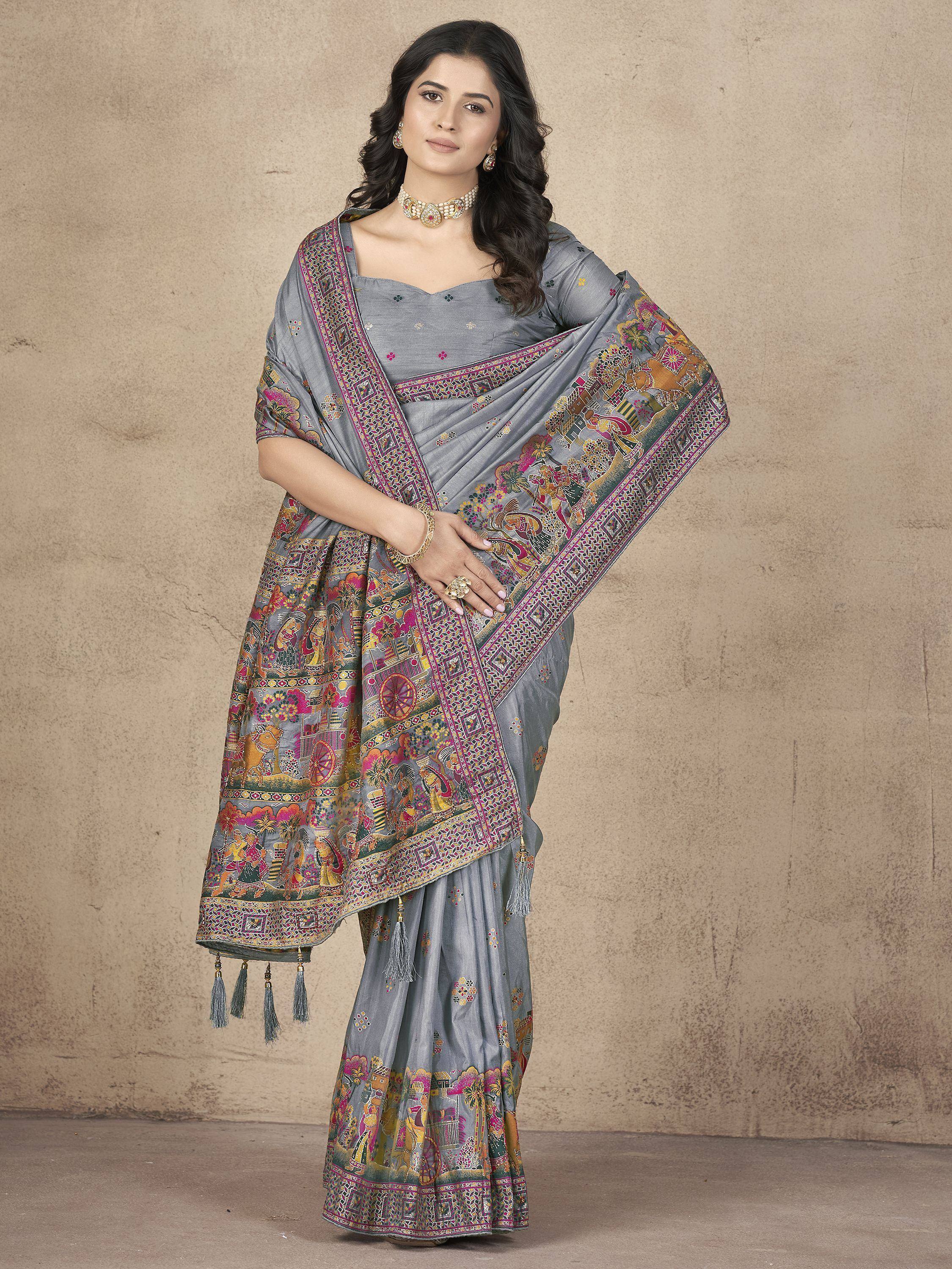 Grey printed saree with colorful folk art border and tassels, paired with matching blouse for ethnic wear