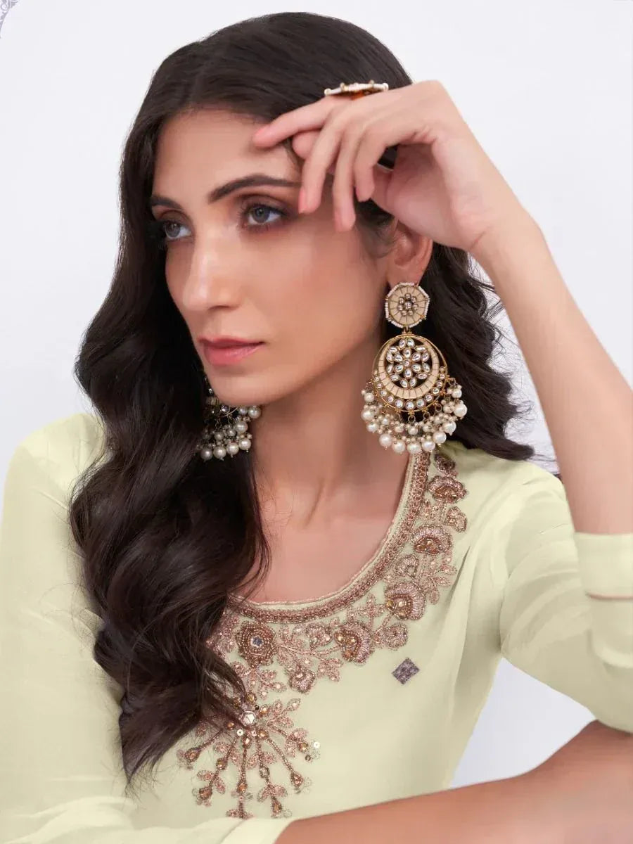 Woman in light green embroidered ethnic top with pearl jhumka earrings, styled for Indian occasions