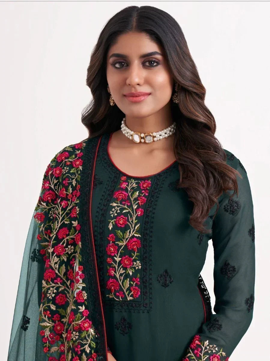 Woman in dark green embroidered salwar kameez with floral dupatta, ethnic jewelry