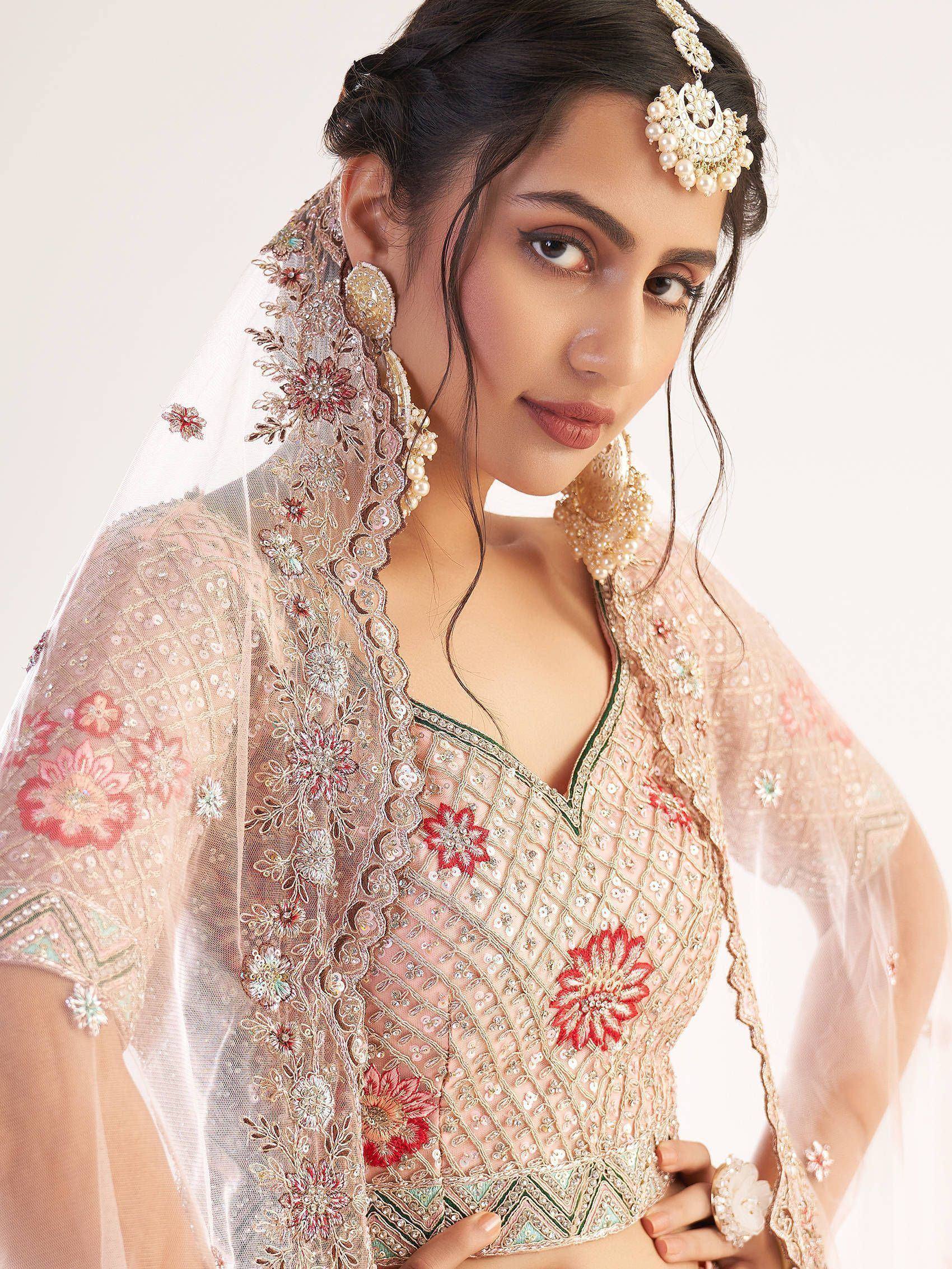 Elegant Indian bridal lehenga choli with floral embroidery, pearl jewelry, and sheer dupatta for wedding wear