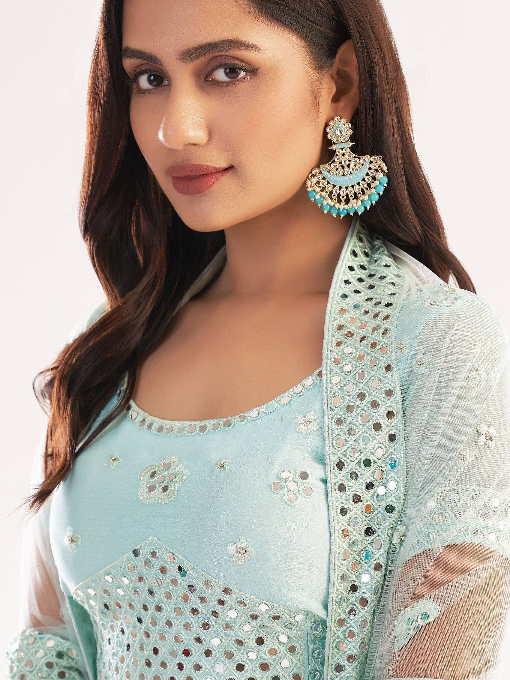 Light blue ethnic salwar kameez with mirror work and floral embroidery, paired with statement jhumka earrings.