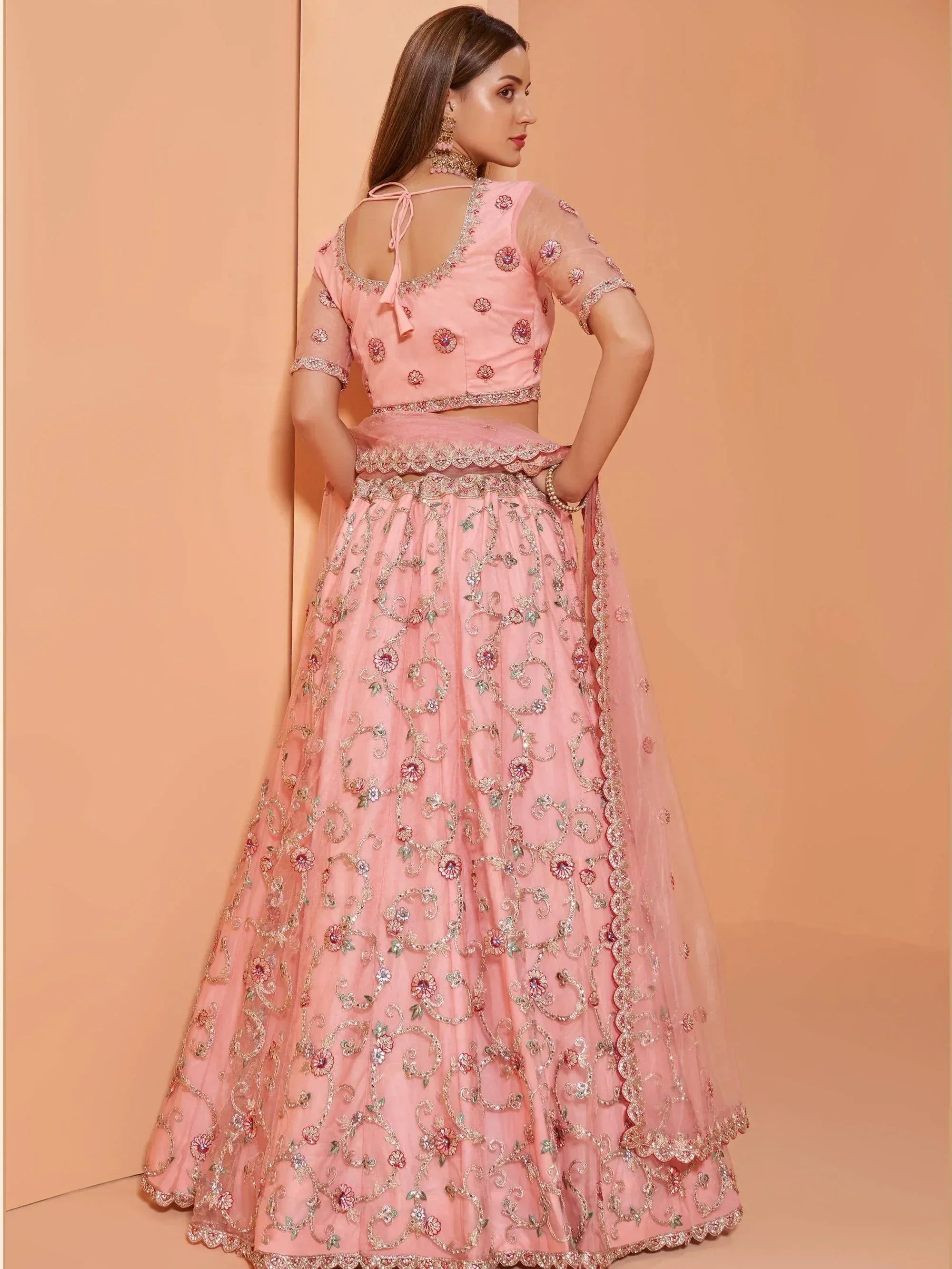 Pink embroidered lehenga choli with floral motifs and sheer sleeves, perfect for Indian ethnic occasions