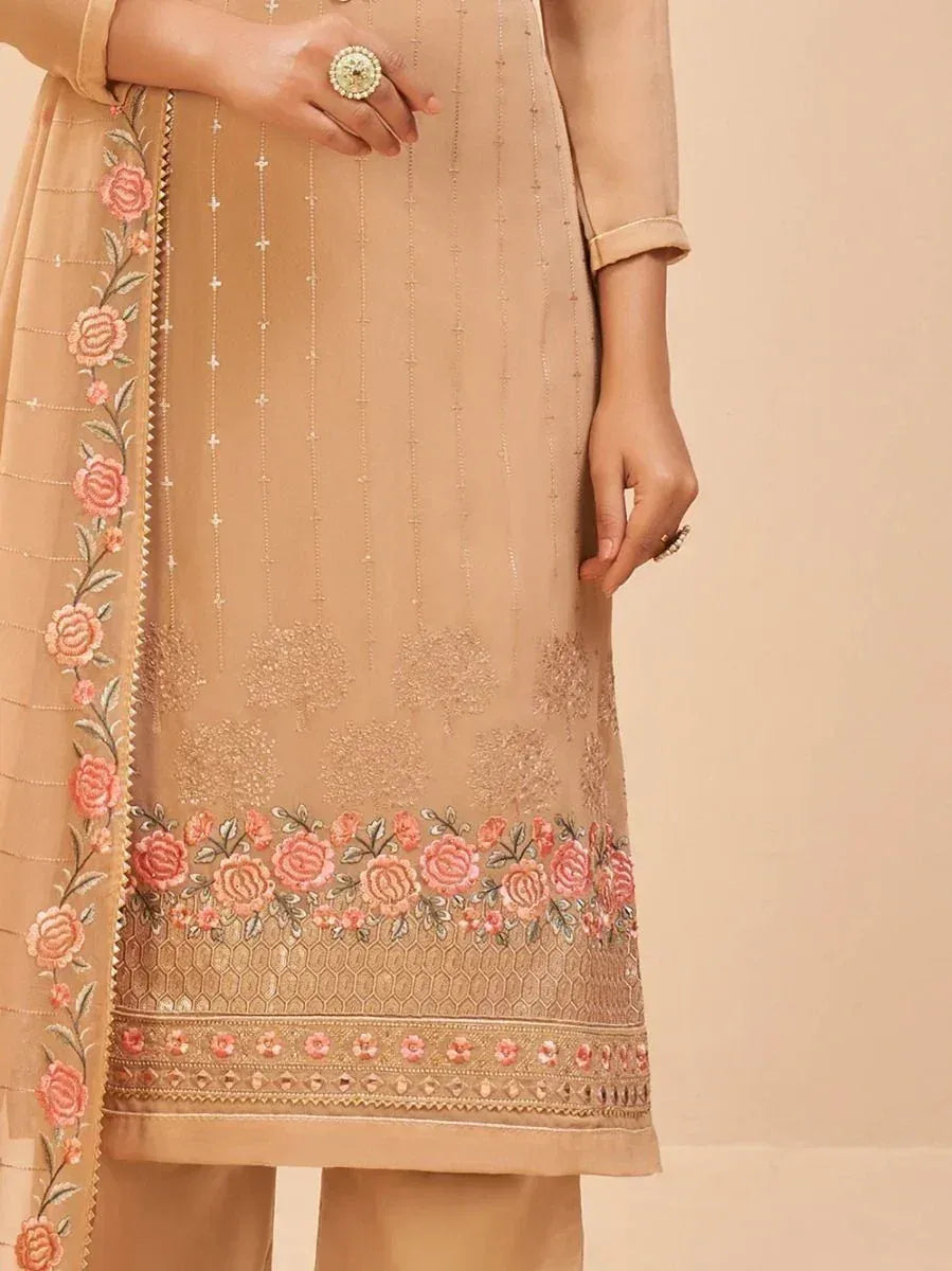 Beige embroidered salwar kameez with pink floral border and delicate thread work, perfect for ethnic occasions.