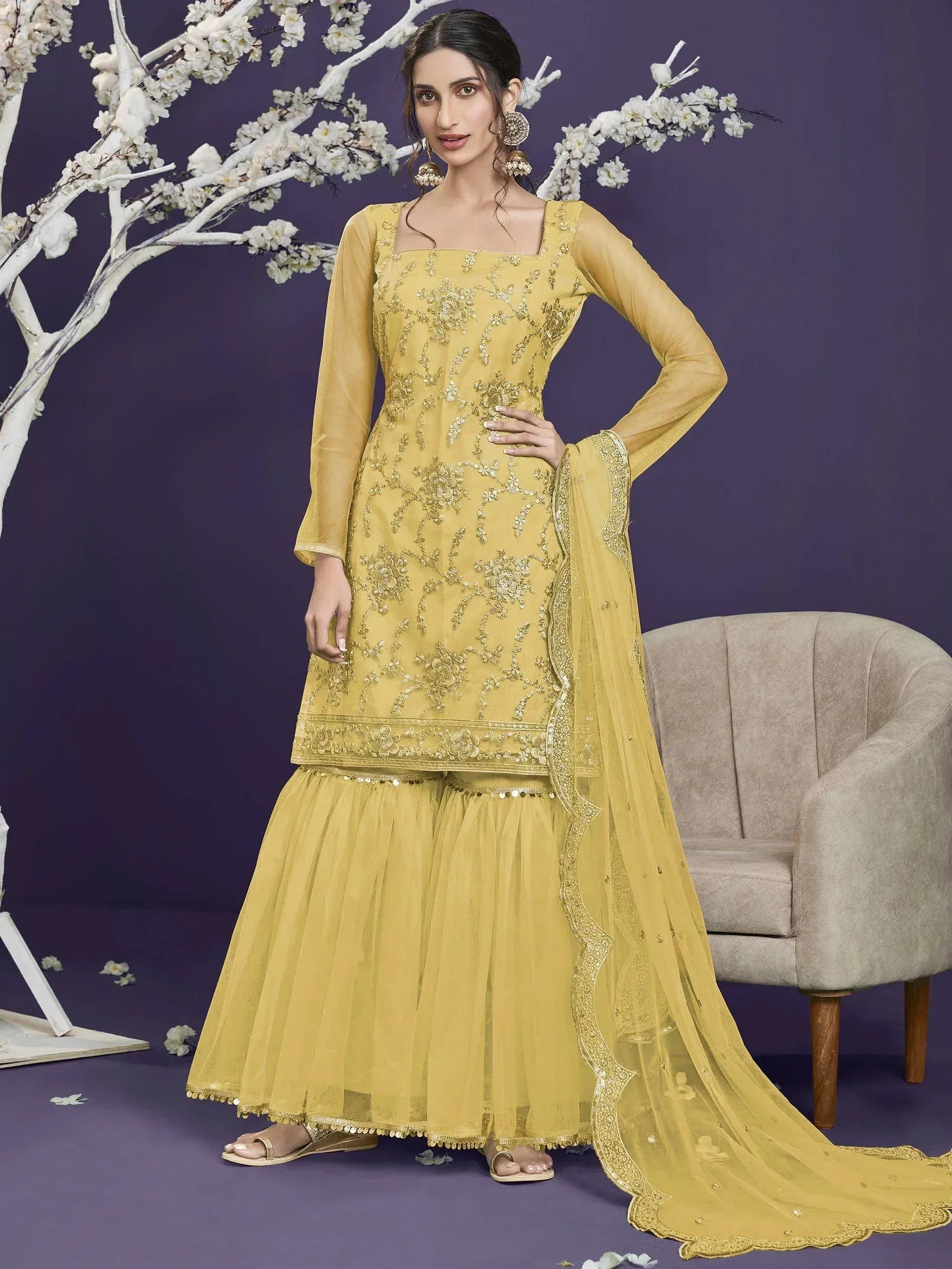 Yellow embroidered salwar kameez with net dupatta, floral embellishments, and flared skirt for ethnic wear