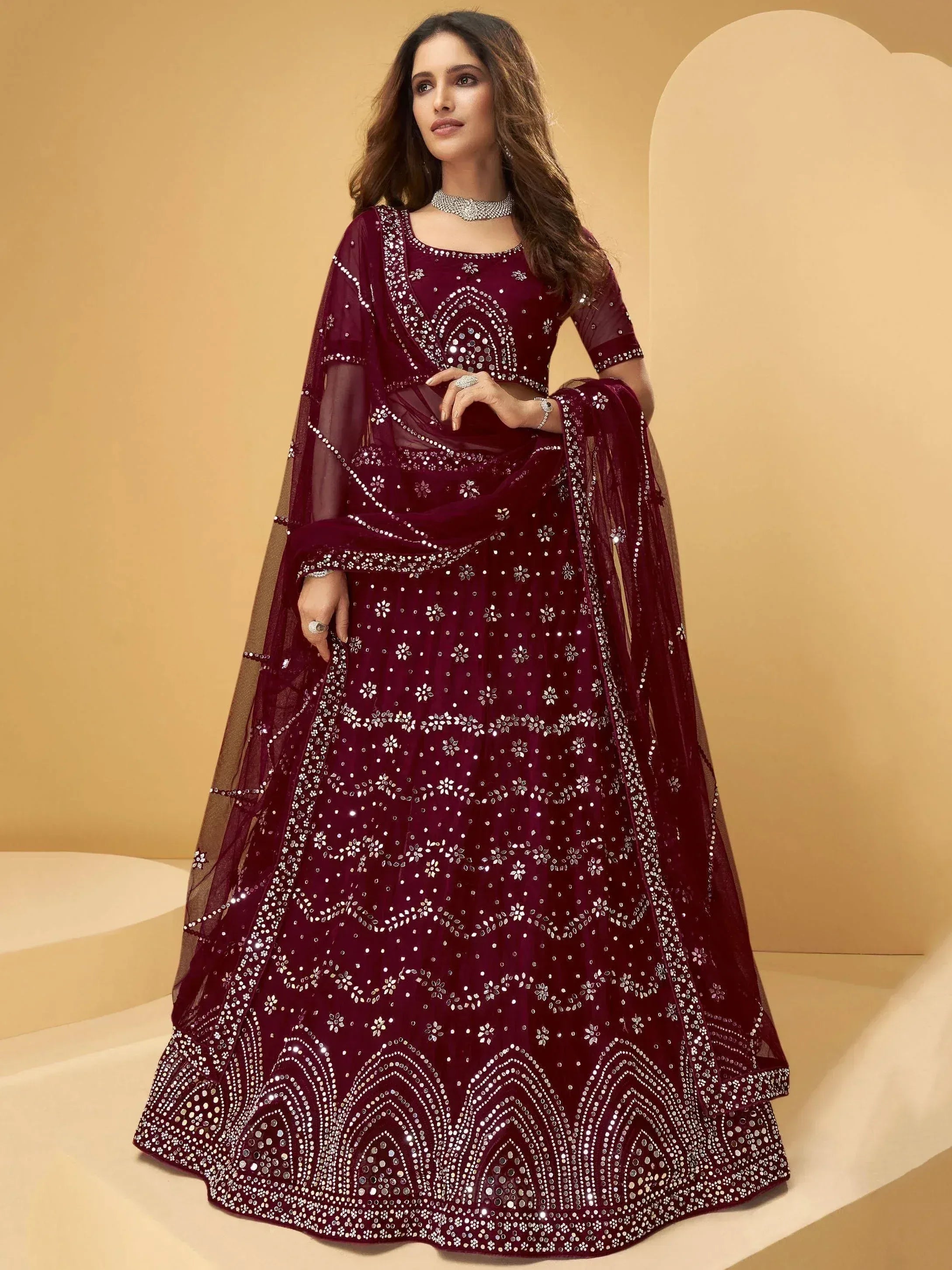 Elegant maroon lehenga choli with heavy mirror and sequin embroidery, perfect for Indian weddings and festive occasions.