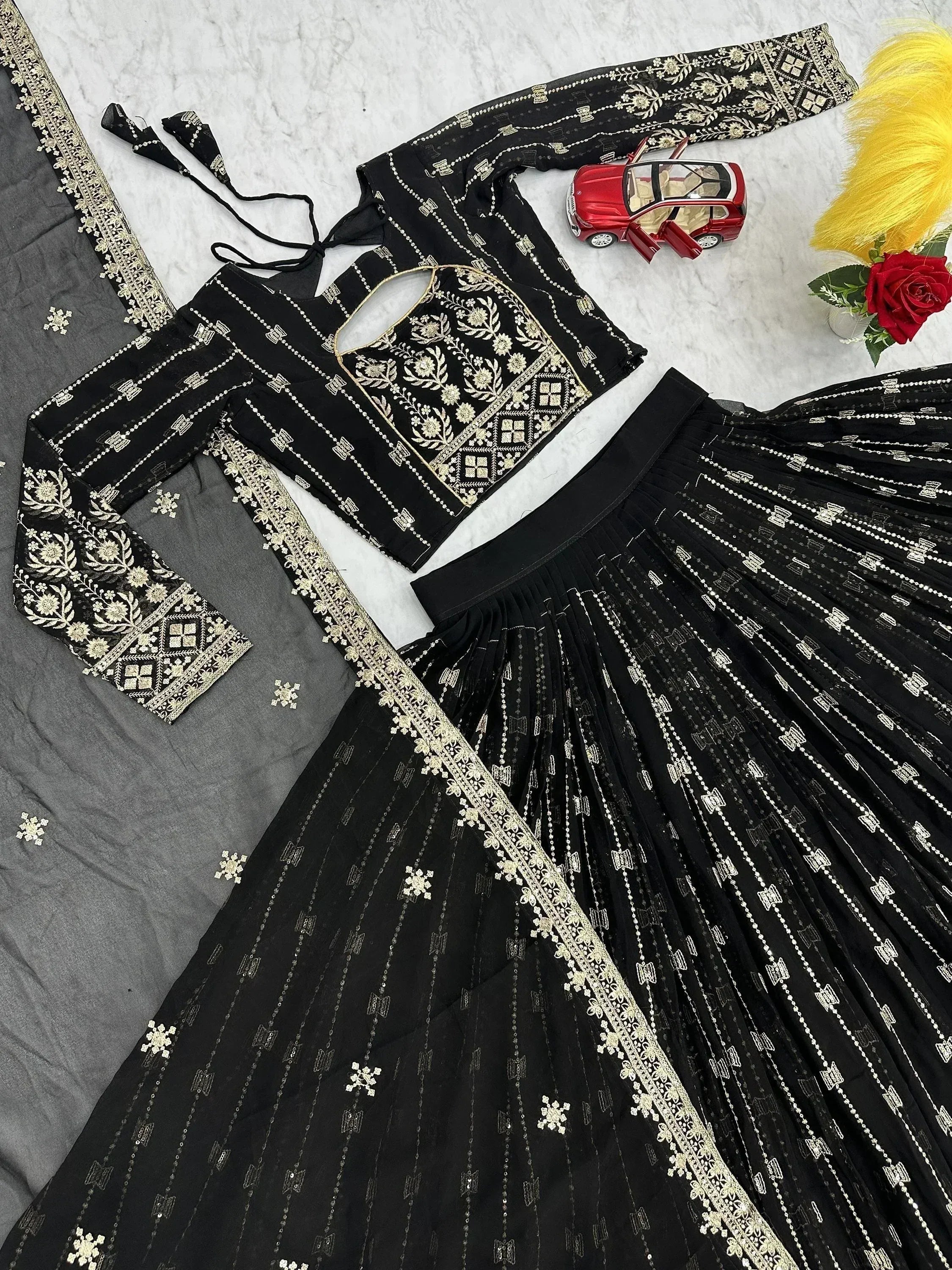 Black embroidered lehenga choli with gold floral work, pleated skirt, and matching dupatta for ethnic wear