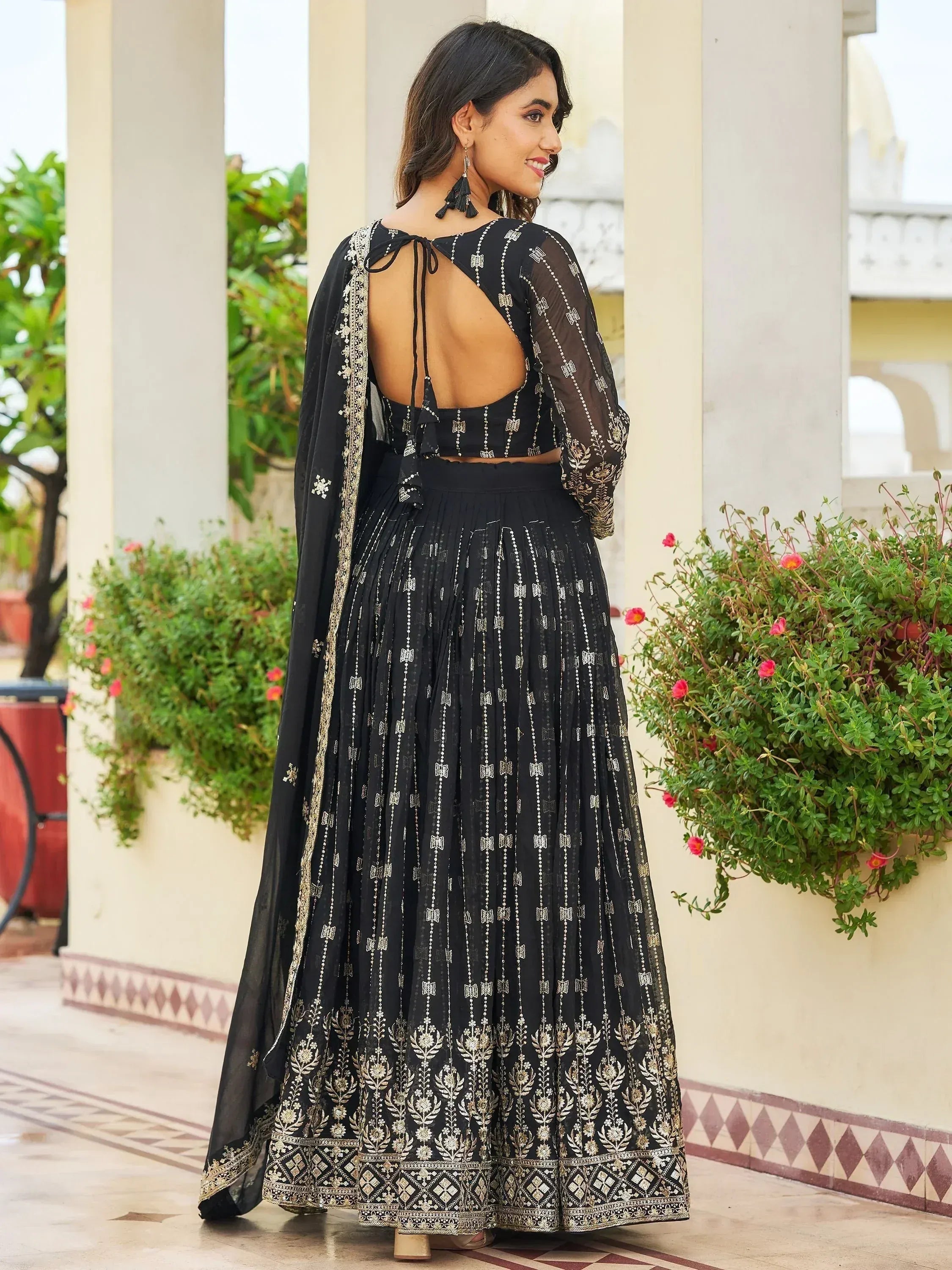 Black embroidered lehenga choli with sheer sleeves and open back, perfect for Indian ethnic wear occasions