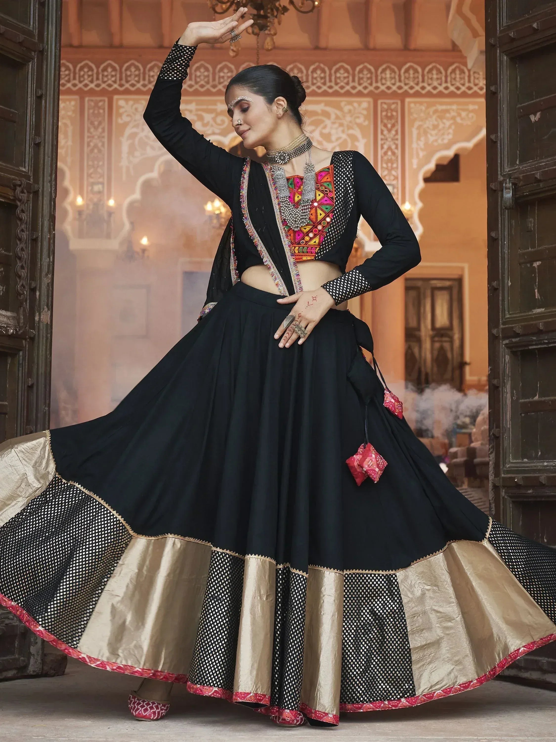 Black ethnic lehenga choli with colorful embroidery and gold border, perfect for Indian weddings or festivals