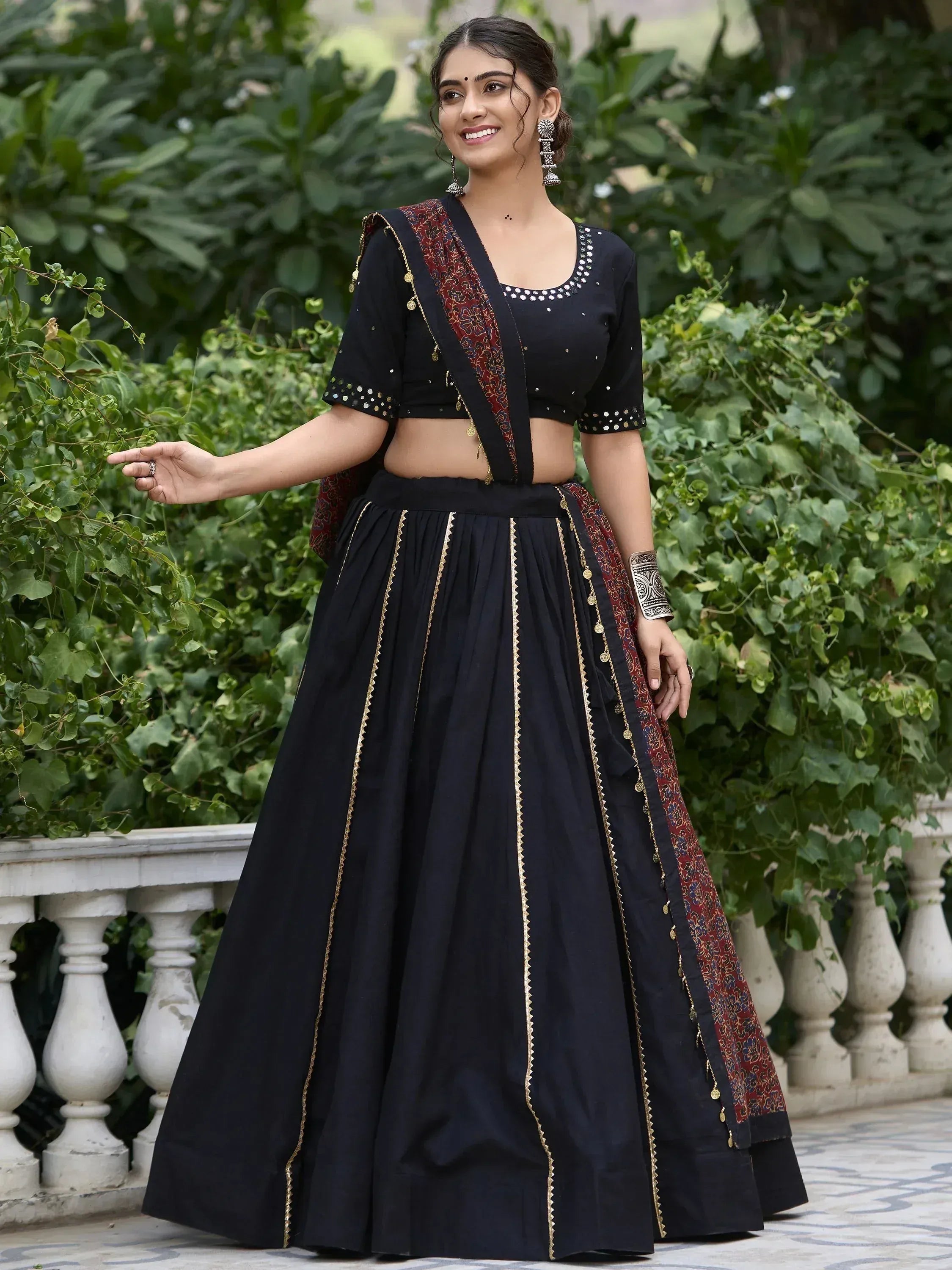 Black ethnic lehenga choli with gold trim and red floral dupatta, perfect for Indian weddings or festive occasions