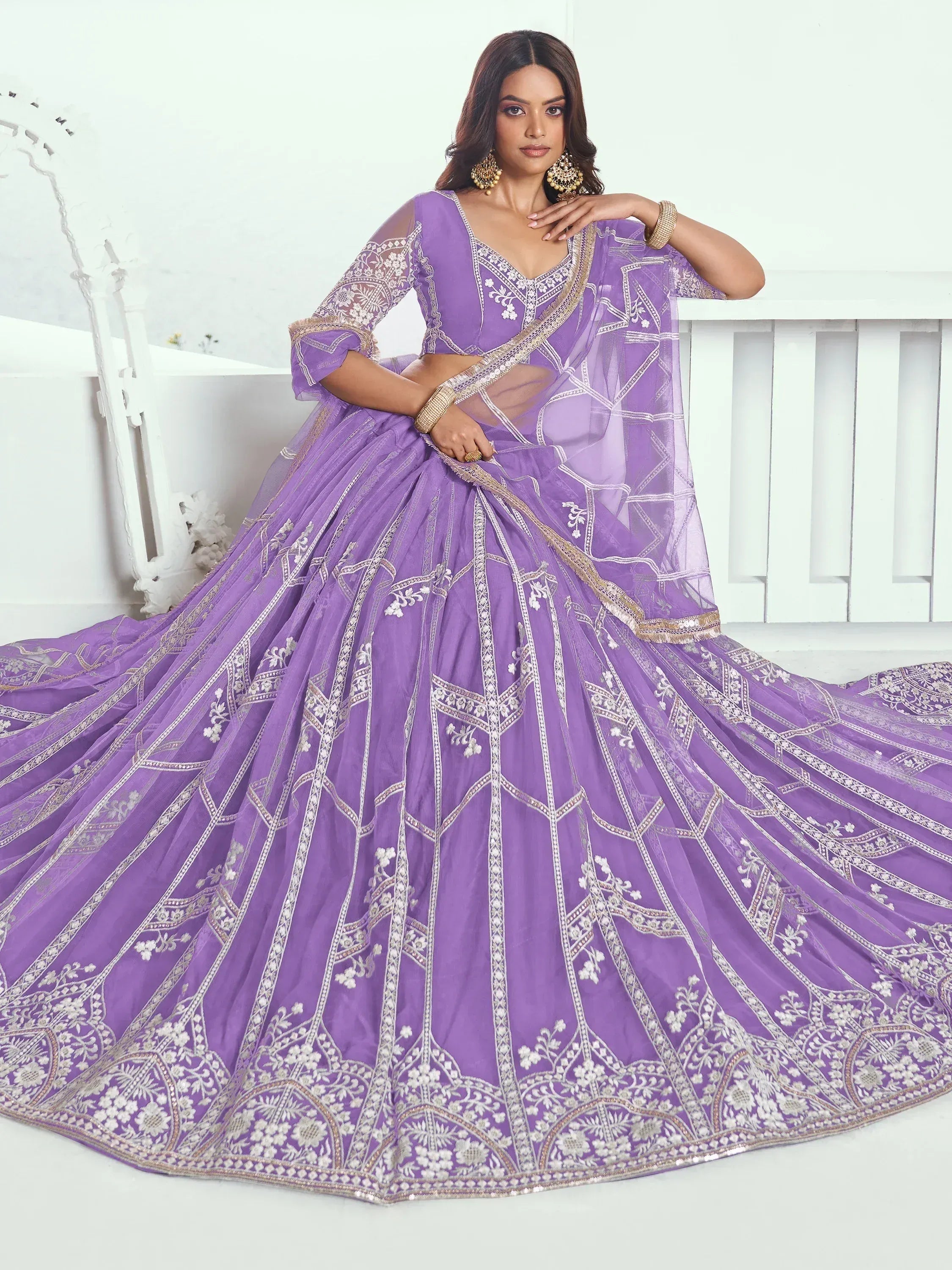 Purple designer lehenga choli with intricate white and gold embroidery, perfect for weddings and festive occasions.