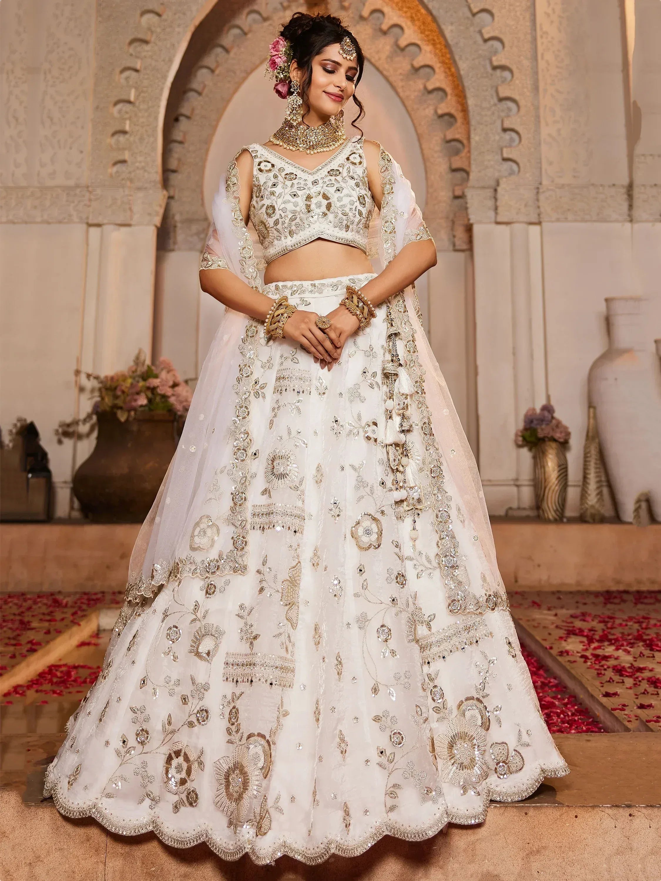 Elegant white bridal lehenga choli with gold embroidery, perfect for Indian weddings and festive occasions.