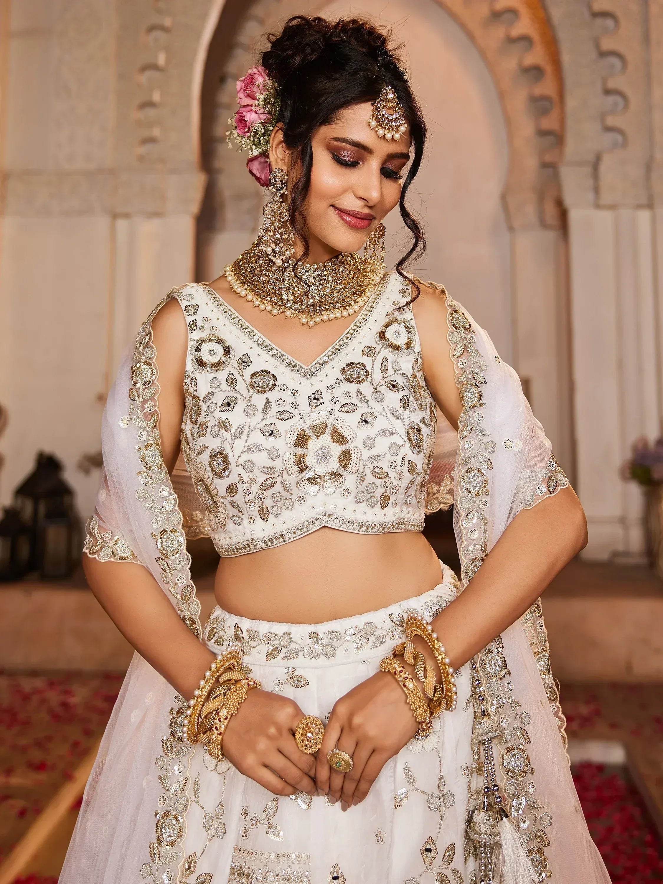 Elegant white embroidered lehenga choli with gold detailing, perfect for Indian weddings and festive occasions.