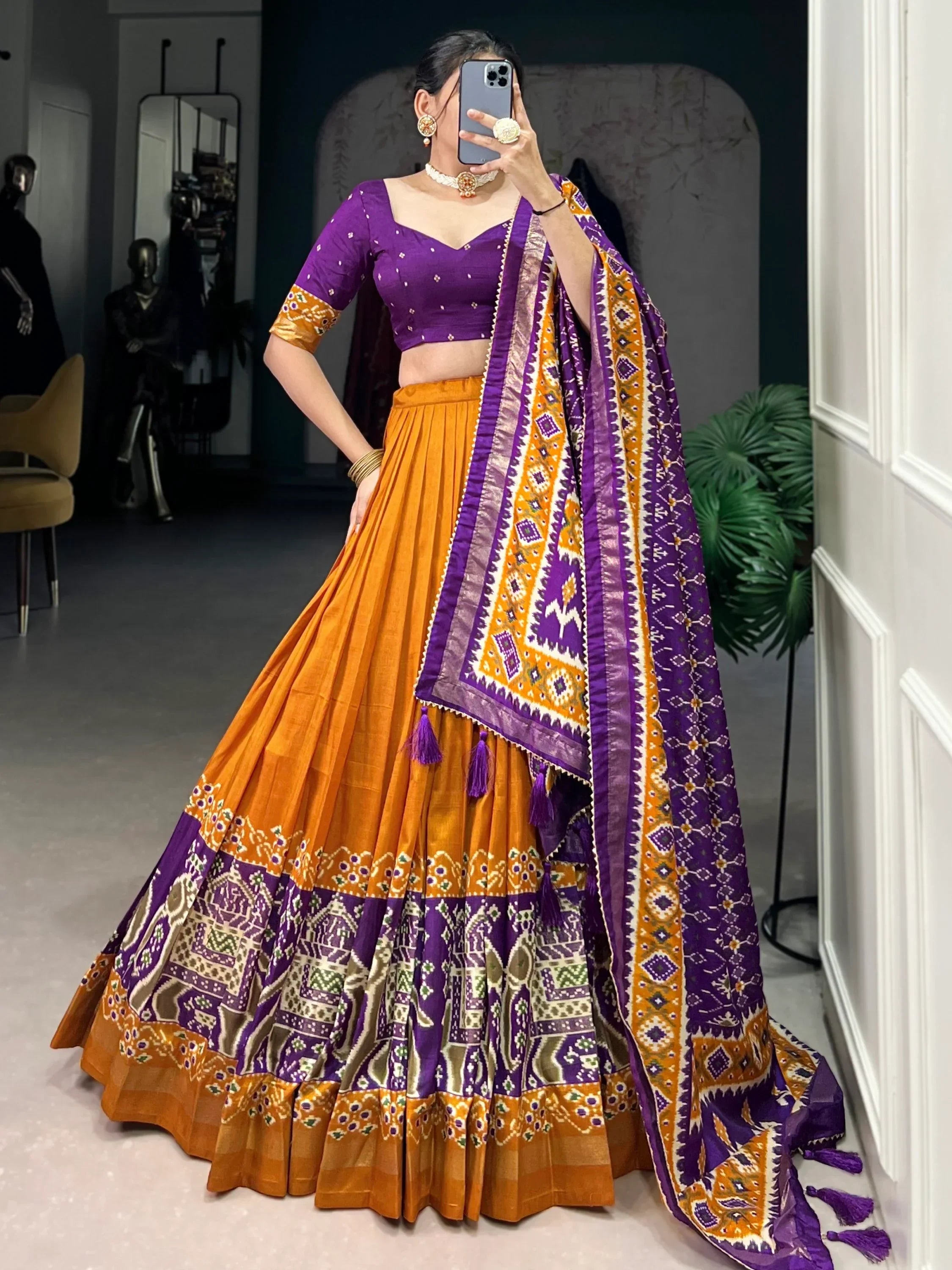 Purple and orange designer lehenga choli with intricate patterns and matching dupatta, perfect for ethnic occasions.