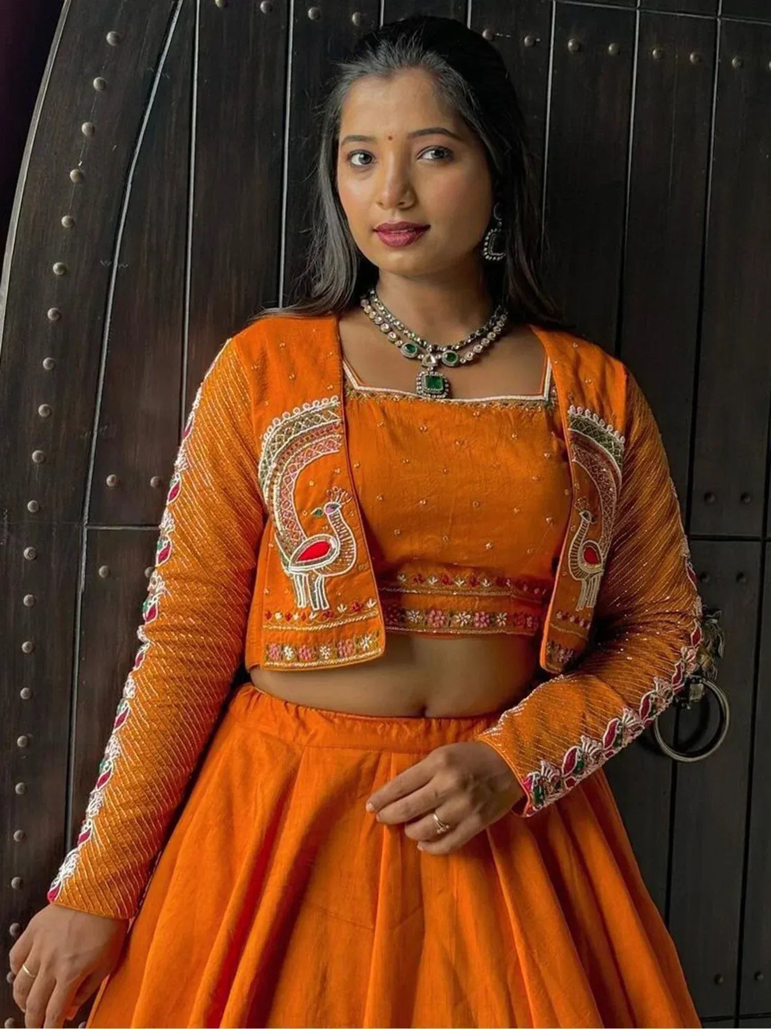 Orange embroidered lehenga choli with peacock motifs, perfect for Indian ethnic wear occasions