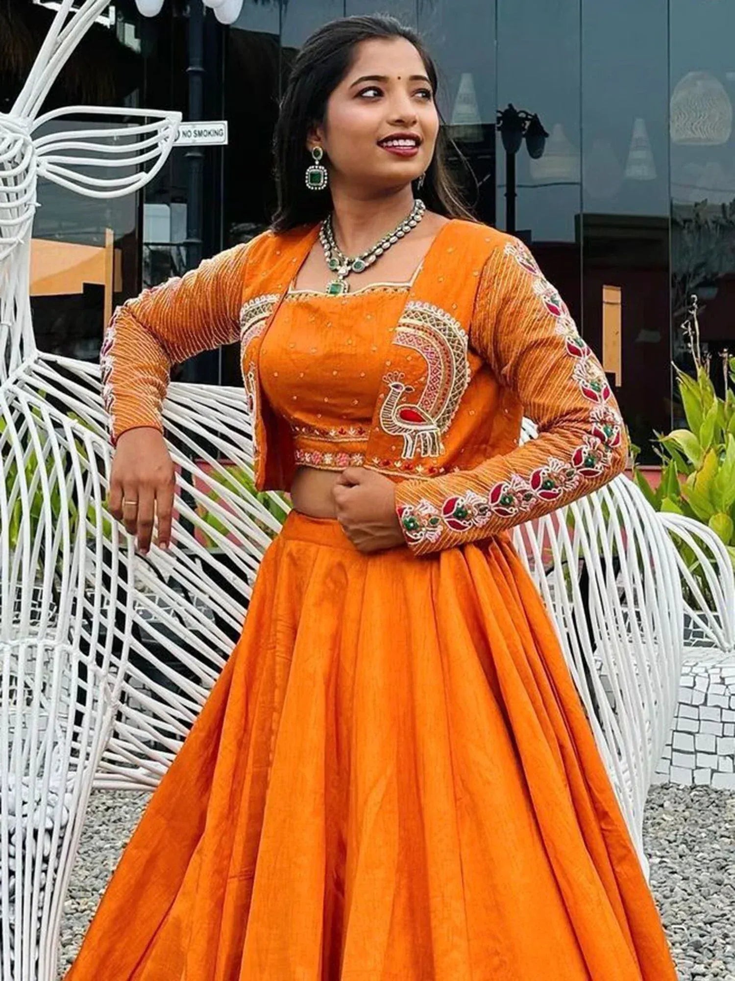 Vibrant orange lehenga choli with peacock embroidery, perfect for Indian ethnic wear occasions.