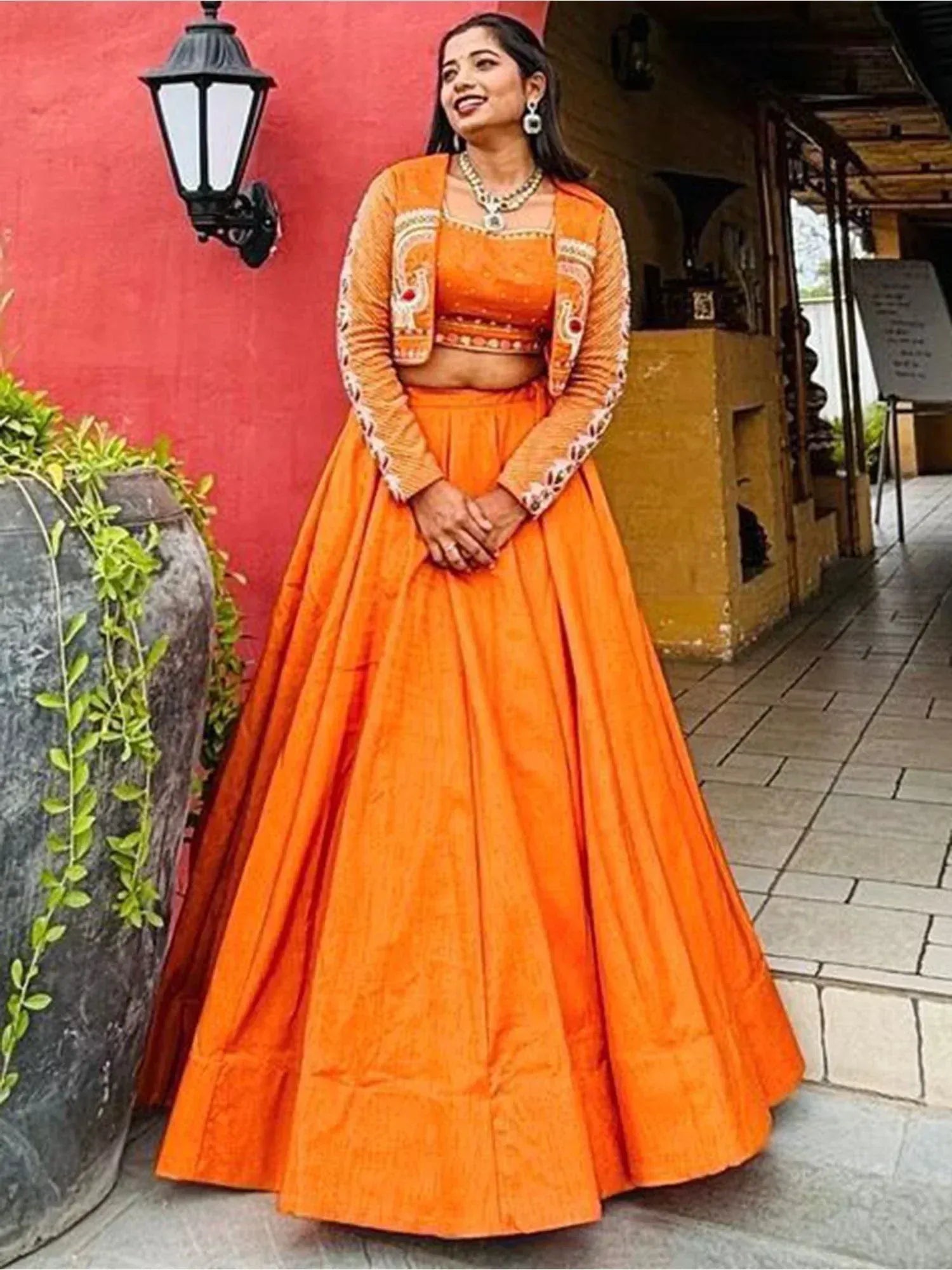 Vibrant orange designer lehenga choli with embroidered jacket, perfect for Indian ethnic occasions