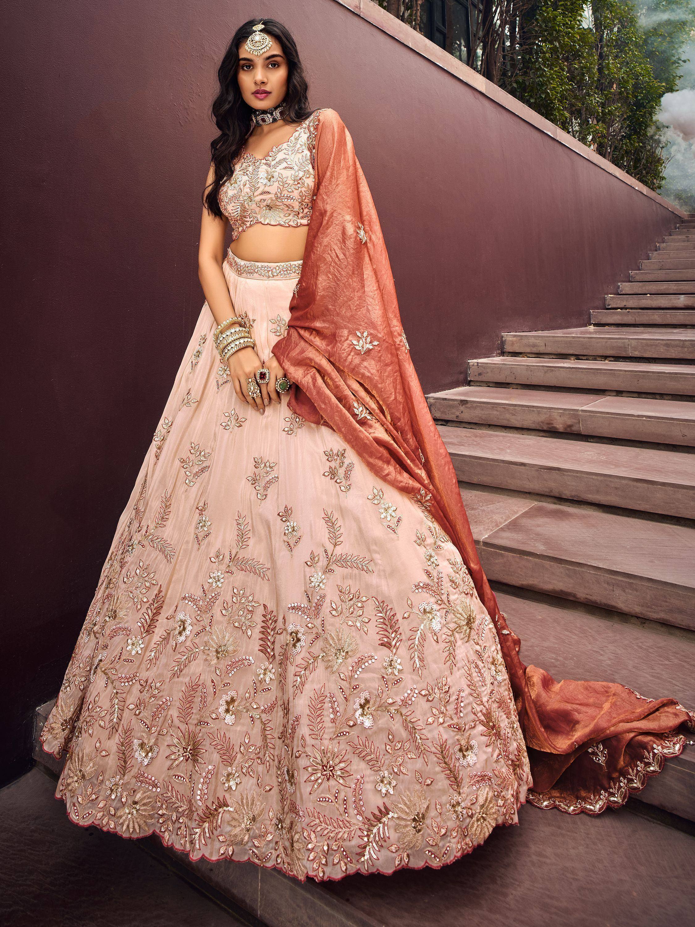 Elegant blush pink lehenga choli with gold floral embroidery and matching dupatta, perfect for weddings and festive occasions.