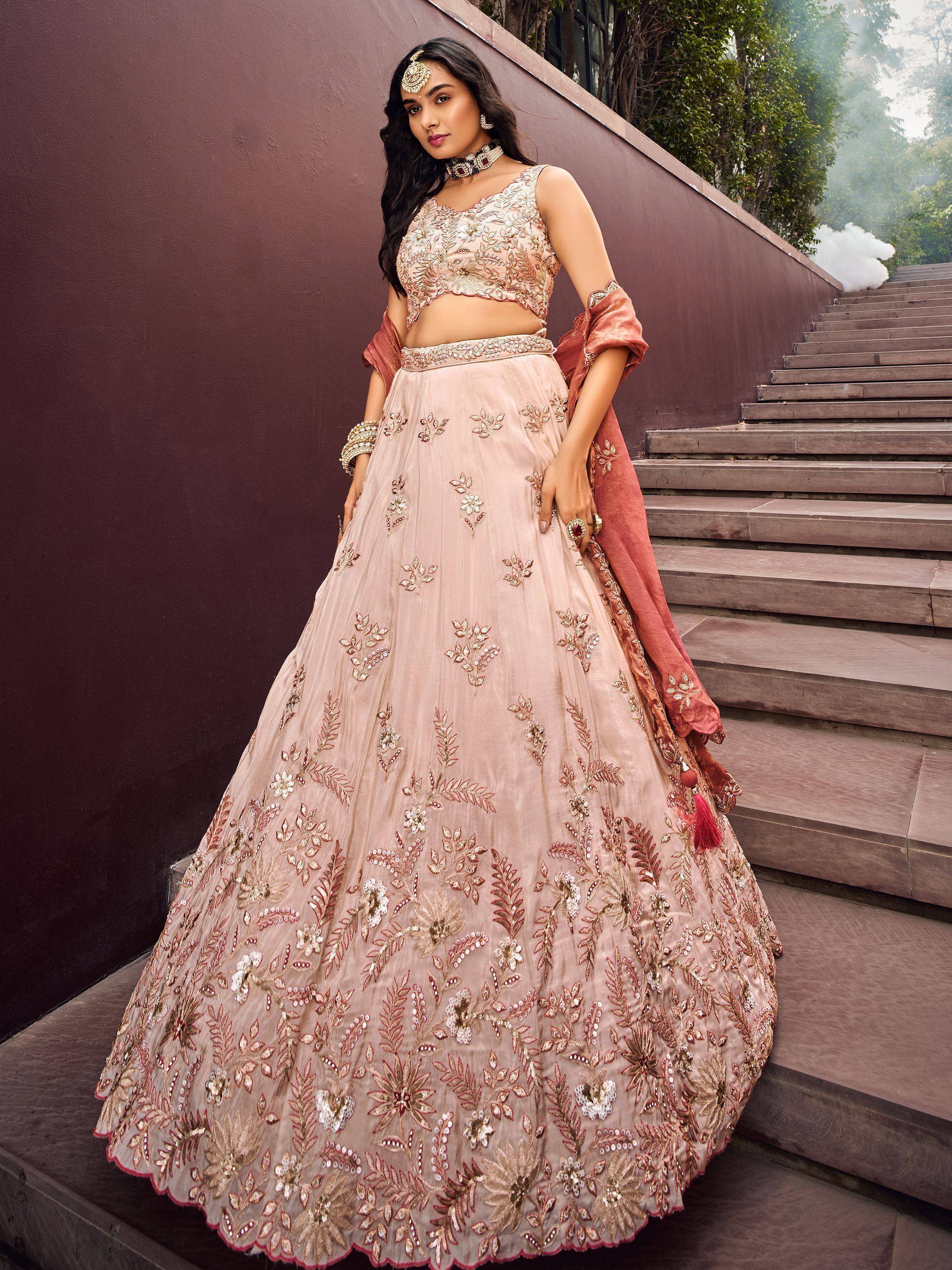 Elegant blush pink embroidered lehenga choli with floral motifs, perfect for Indian weddings and festive occasions.