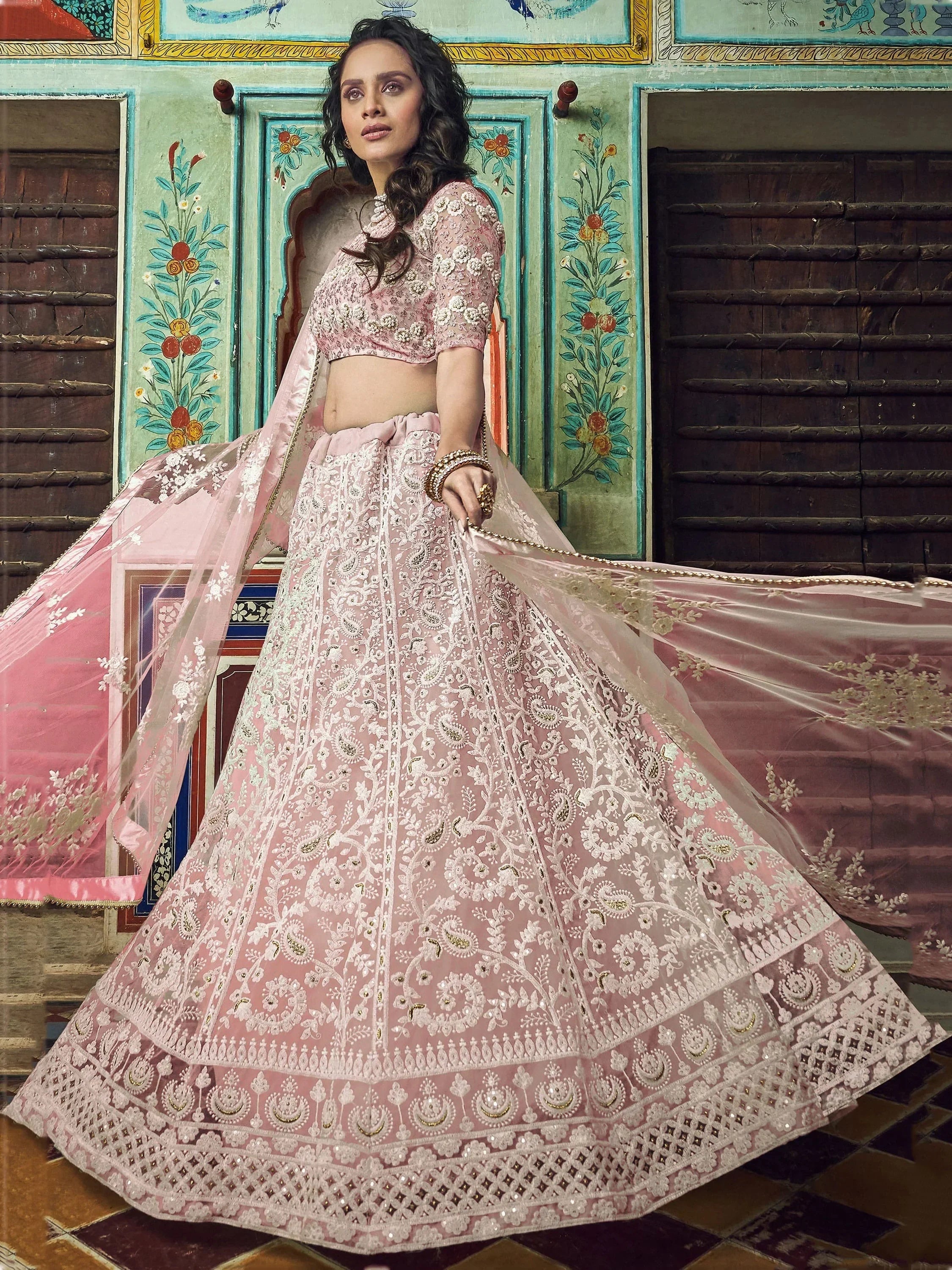 Pink embroidered lehenga choli with floral motifs, perfect for Indian weddings and festive occasions.