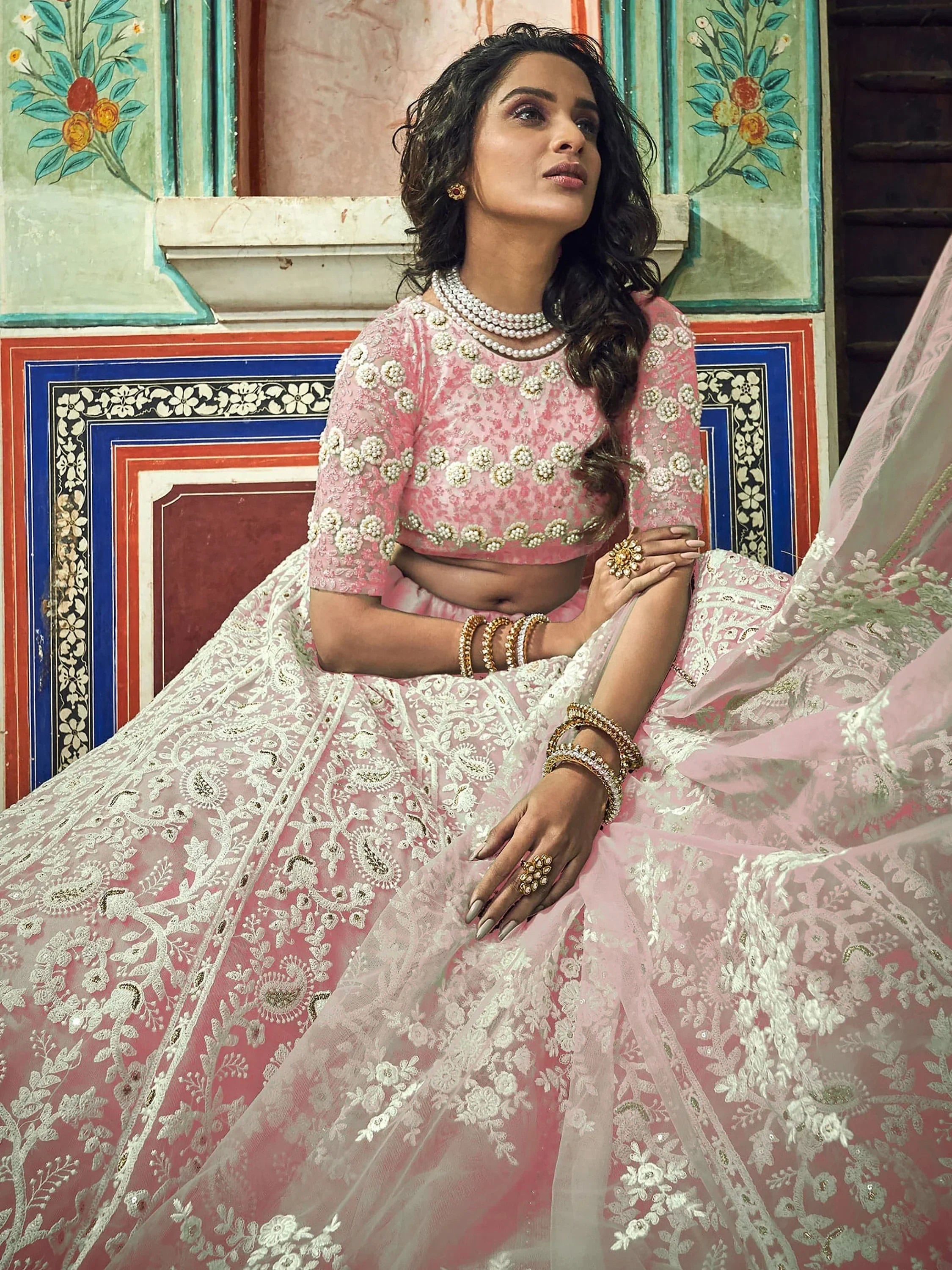 Elegant pink designer lehenga choli with intricate white embroidery, perfect for Indian ethnic wear occasions.