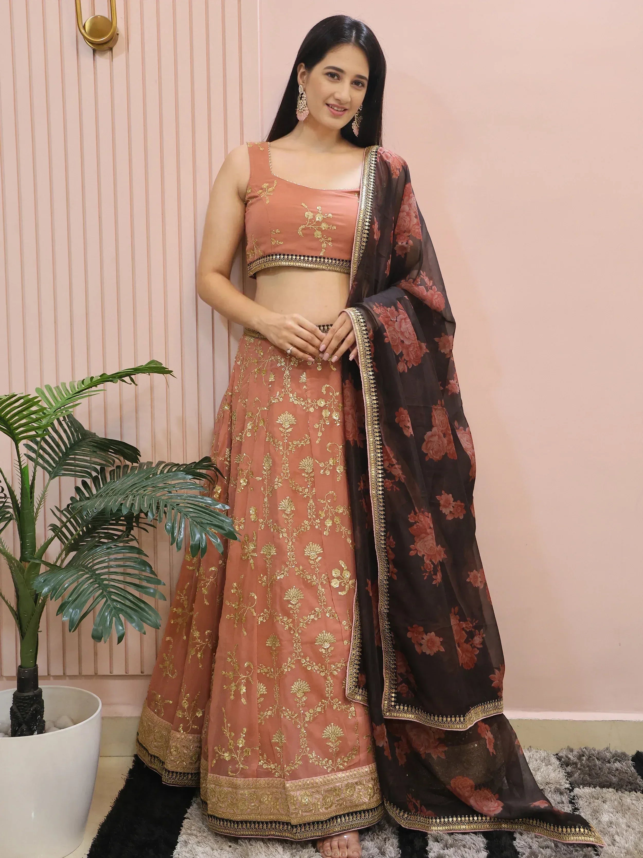 Woman in peach lehenga choli with gold embroidery and floral dupatta, Indian ethnic wear