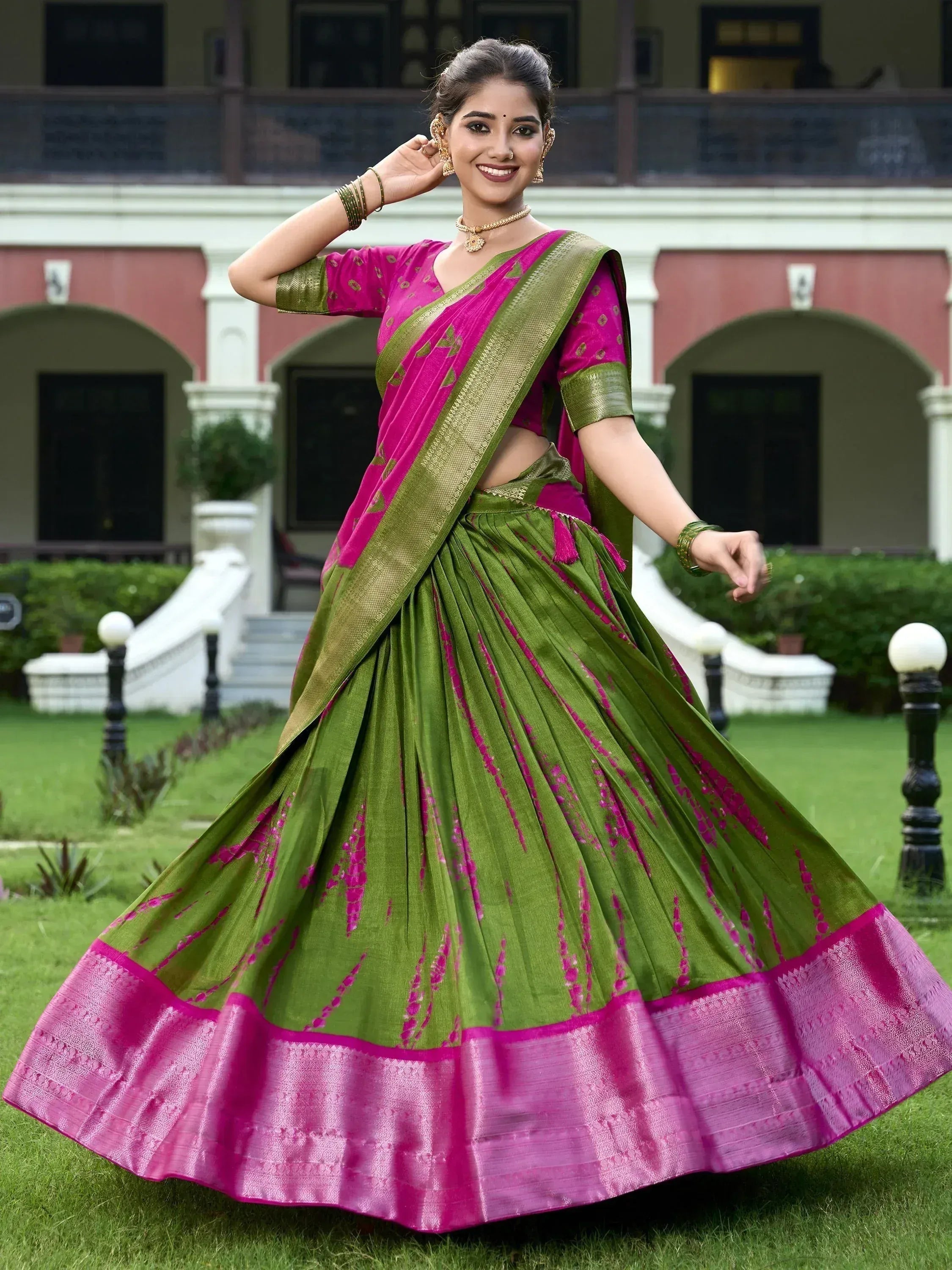Woman in vibrant pink and green designer lehenga choli, perfect for Indian ethnic wear occasions.