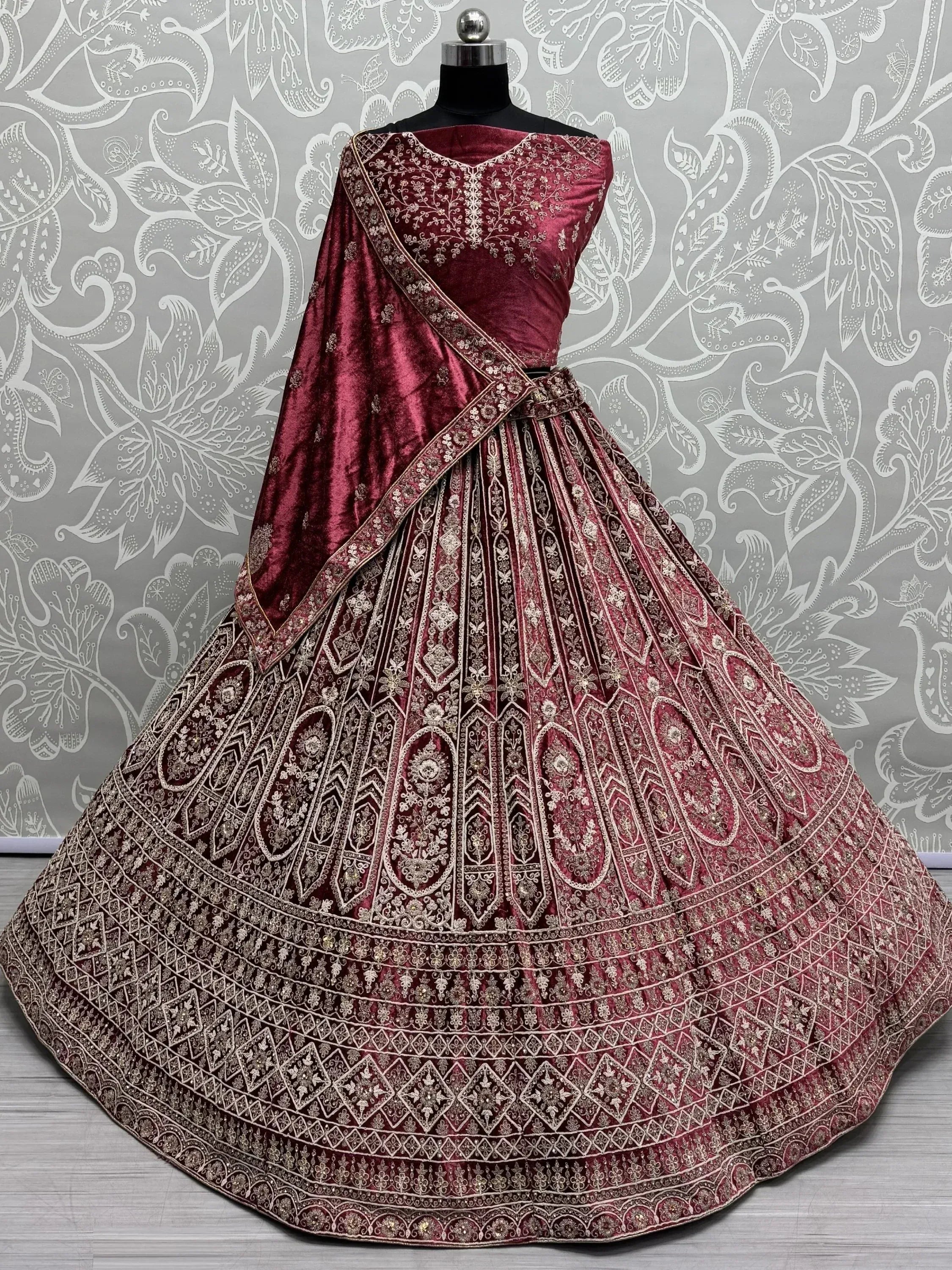 Maroon velvet lehenga choli with gold embroidery, perfect for Indian weddings and festive occasions.
