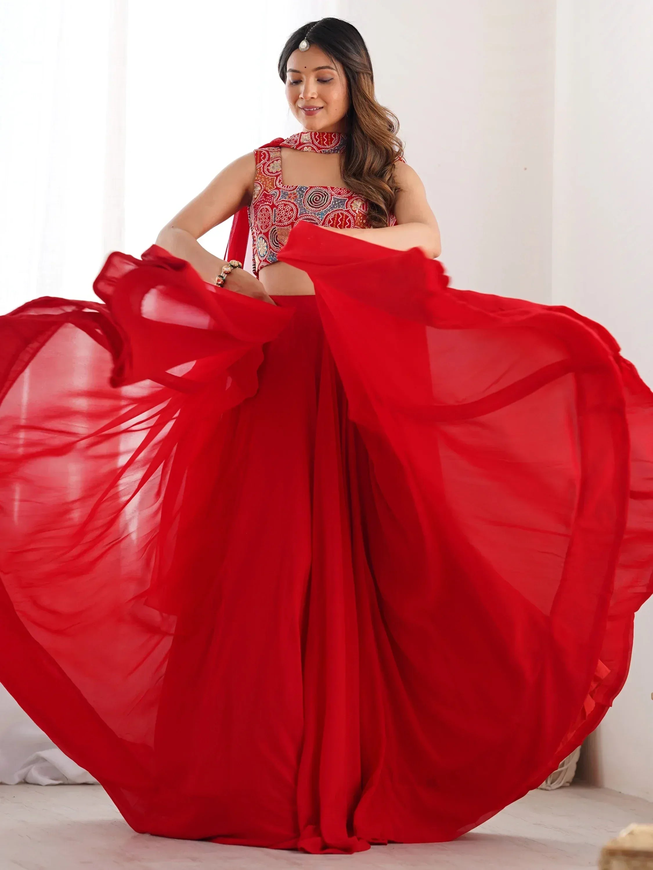 Woman in red ethnic lehenga choli with flowing dupatta, perfect for Indian weddings and festive occasions