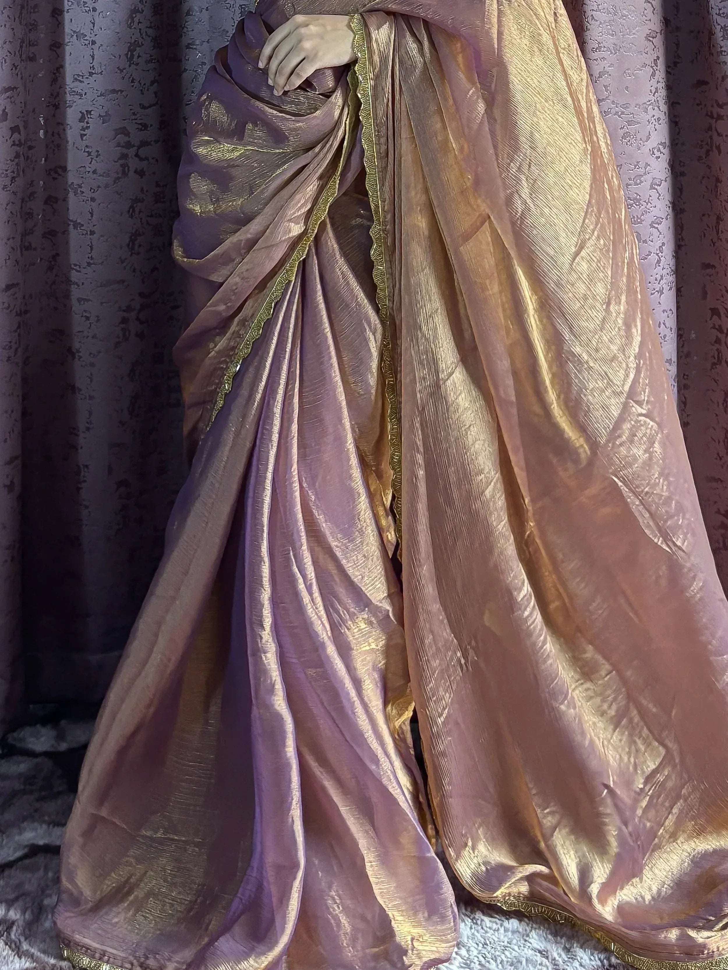 Elegant purple and gold saree with shimmering texture and detailed border, perfect for Indian ethnic wear.