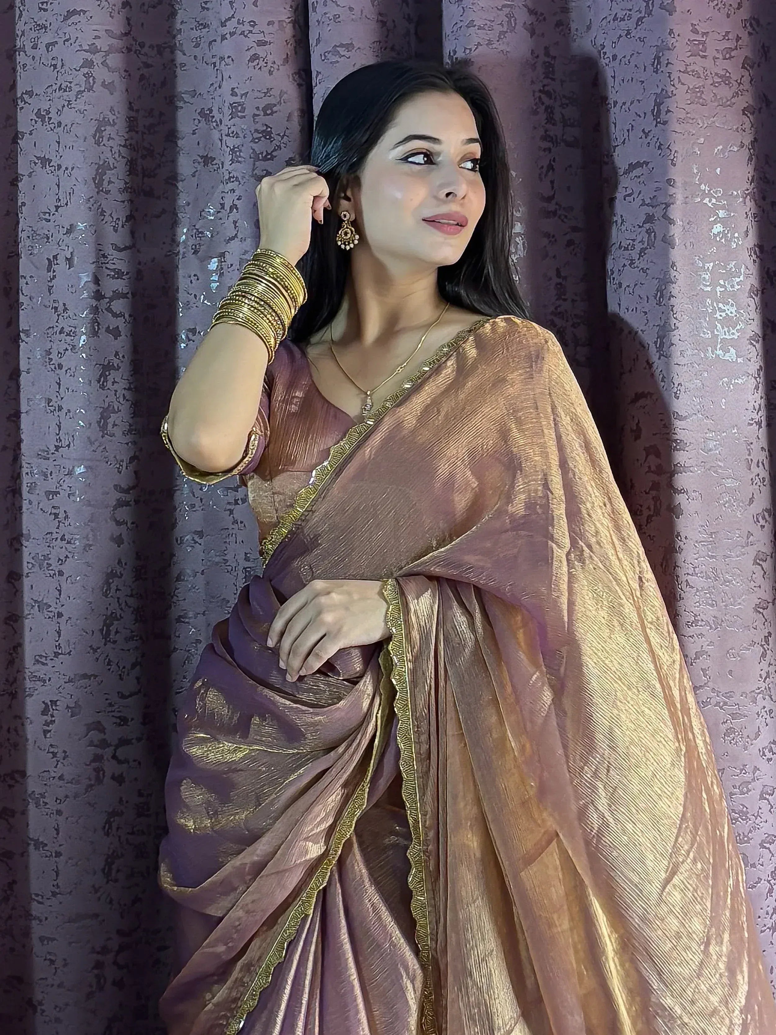 Woman in elegant purple and gold saree with traditional jewelry, perfect for Indian ethnic occasions.