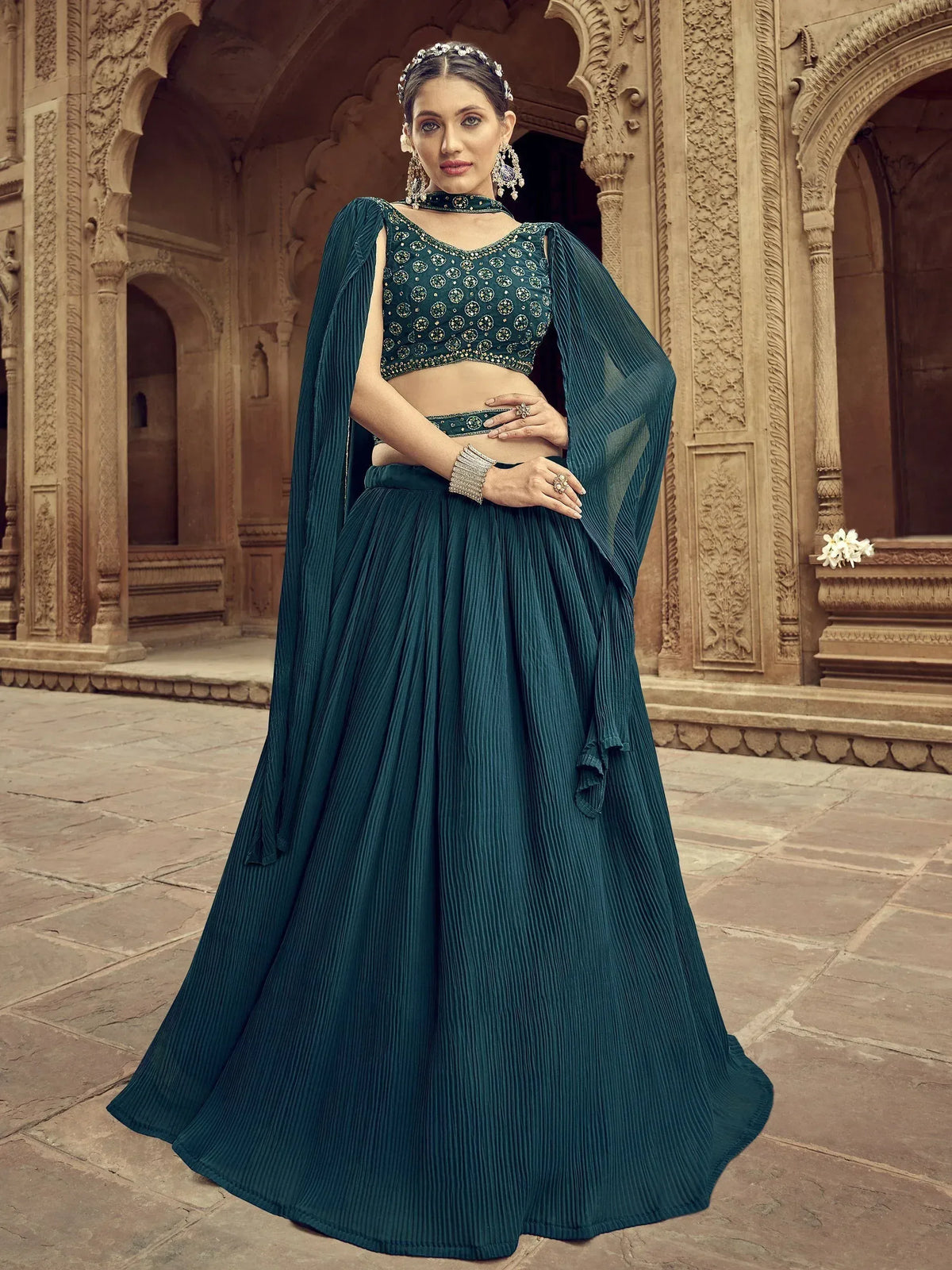 Teal designer lehenga choli with pleated skirt and cape, perfect for Indian ethnic wear occasions.