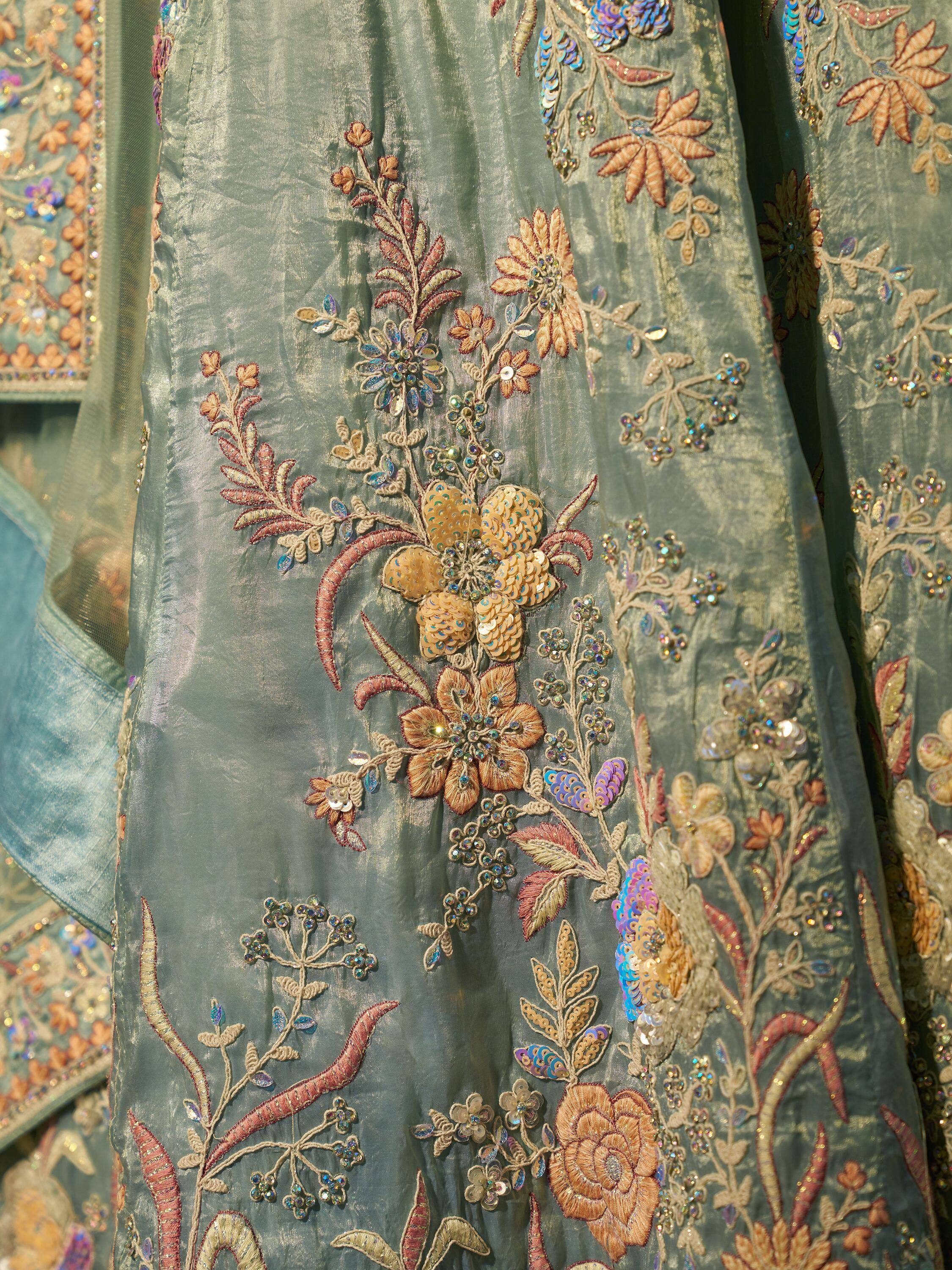 Elegant teal ethnic gown with intricate floral embroidery and sequin detailing for festive occasions.