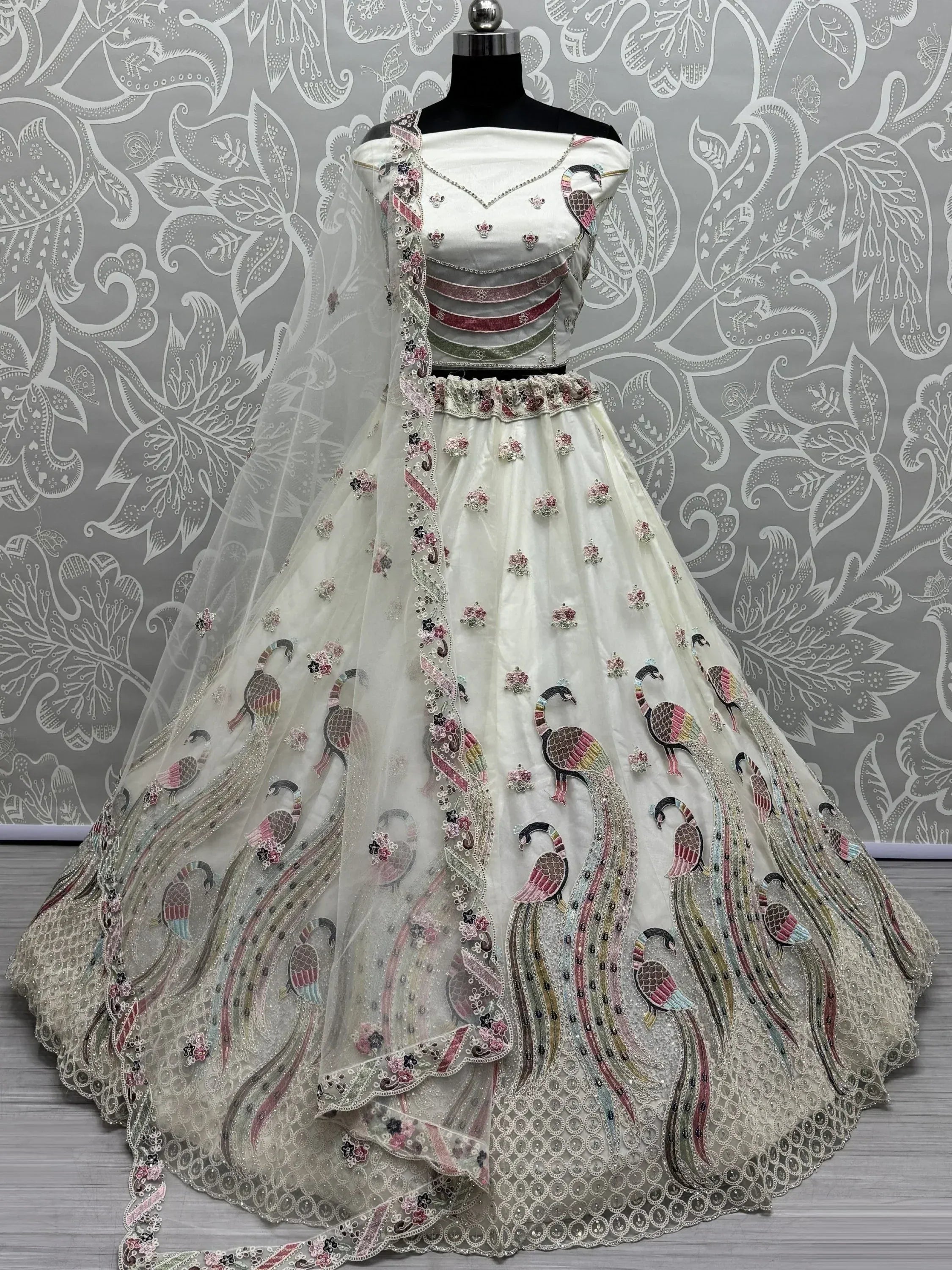 White designer lehenga choli with peacock embroidery, floral motifs, and sheer dupatta for Indian ethnic wear