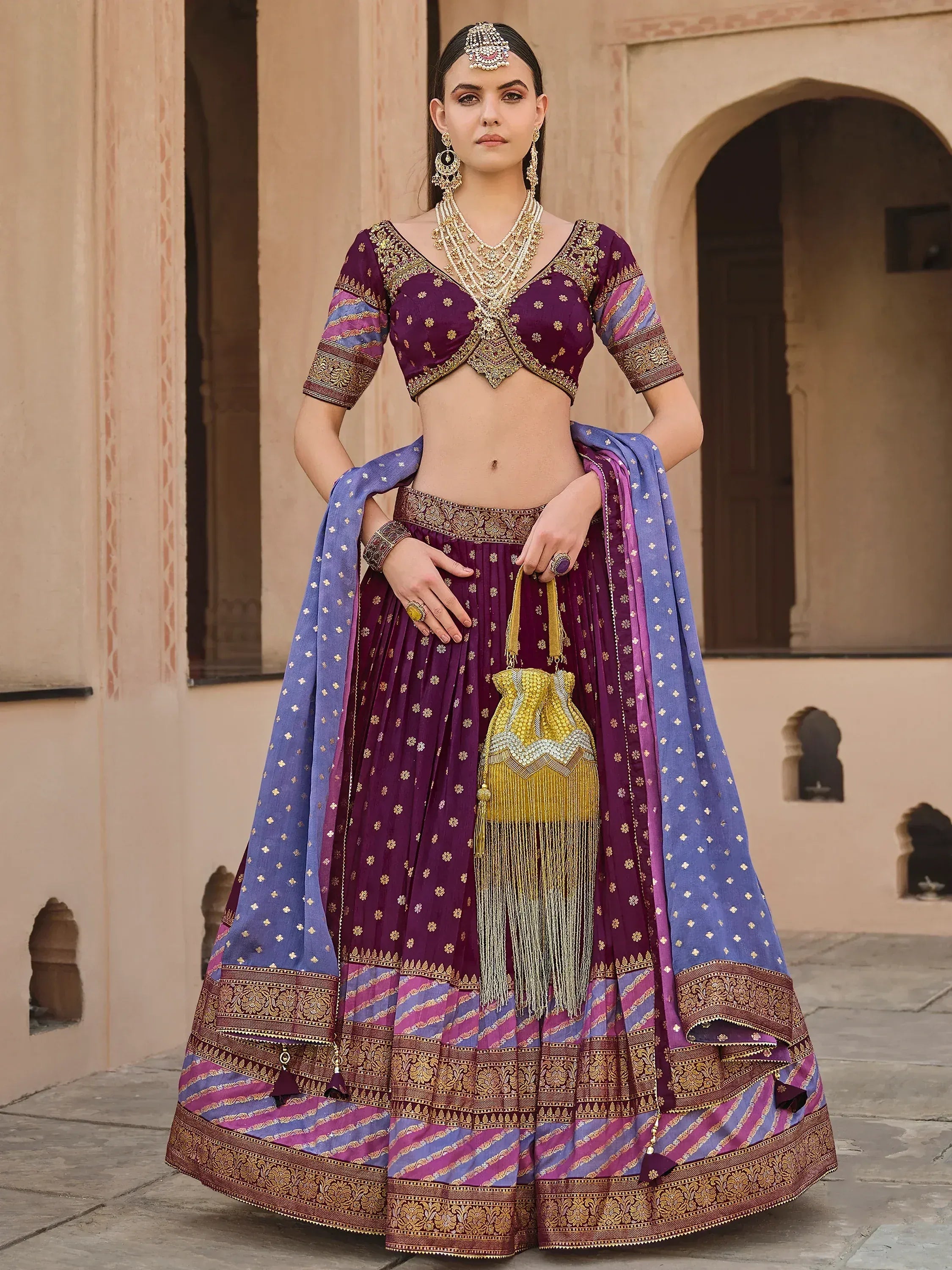 Purple and blue designer lehenga choli with gold embroidery, perfect for Indian weddings and festivals.