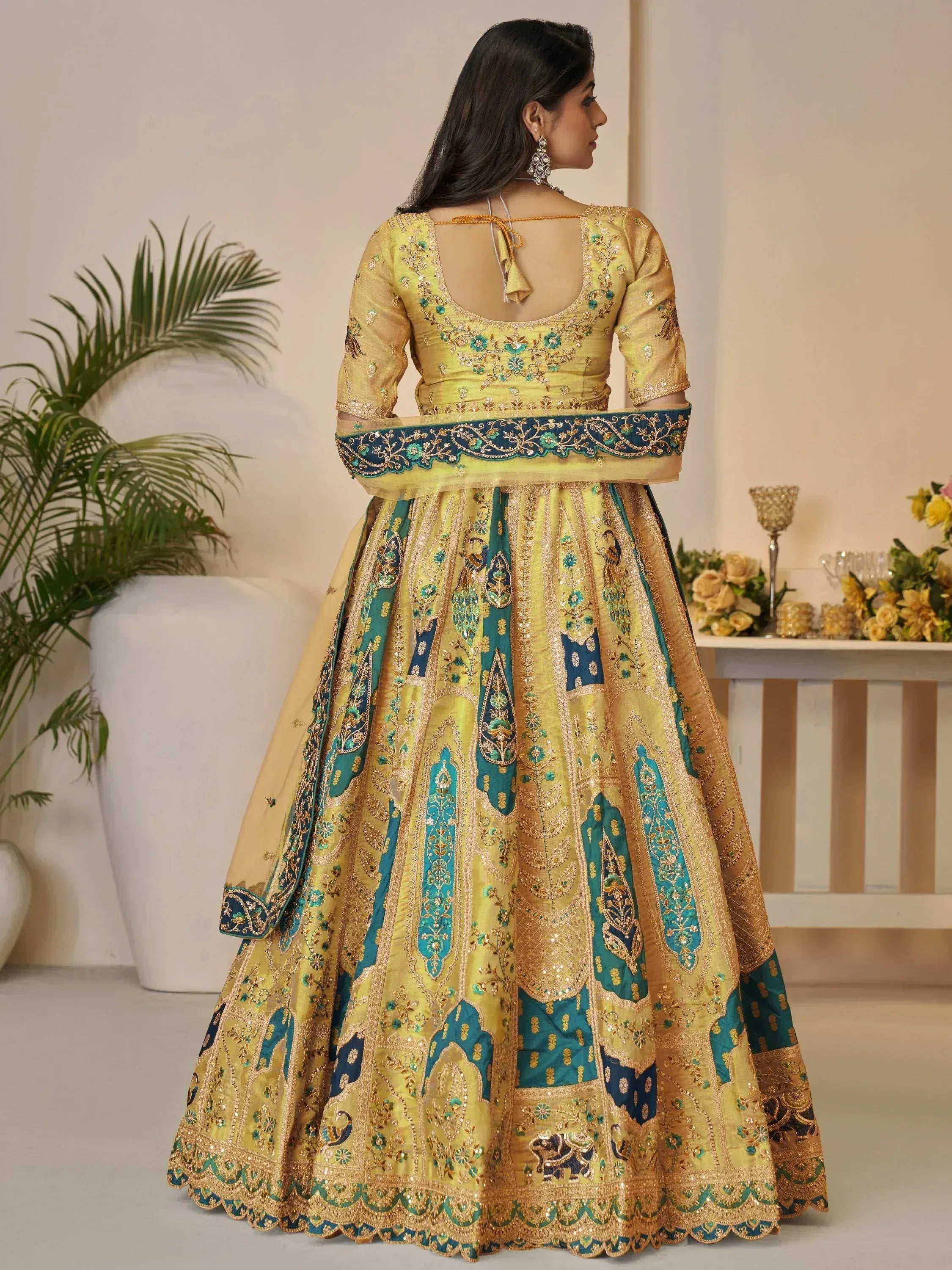 Yellow and teal embroidered lehenga choli with peacock motifs, perfect for Indian ethnic wear occasions.
