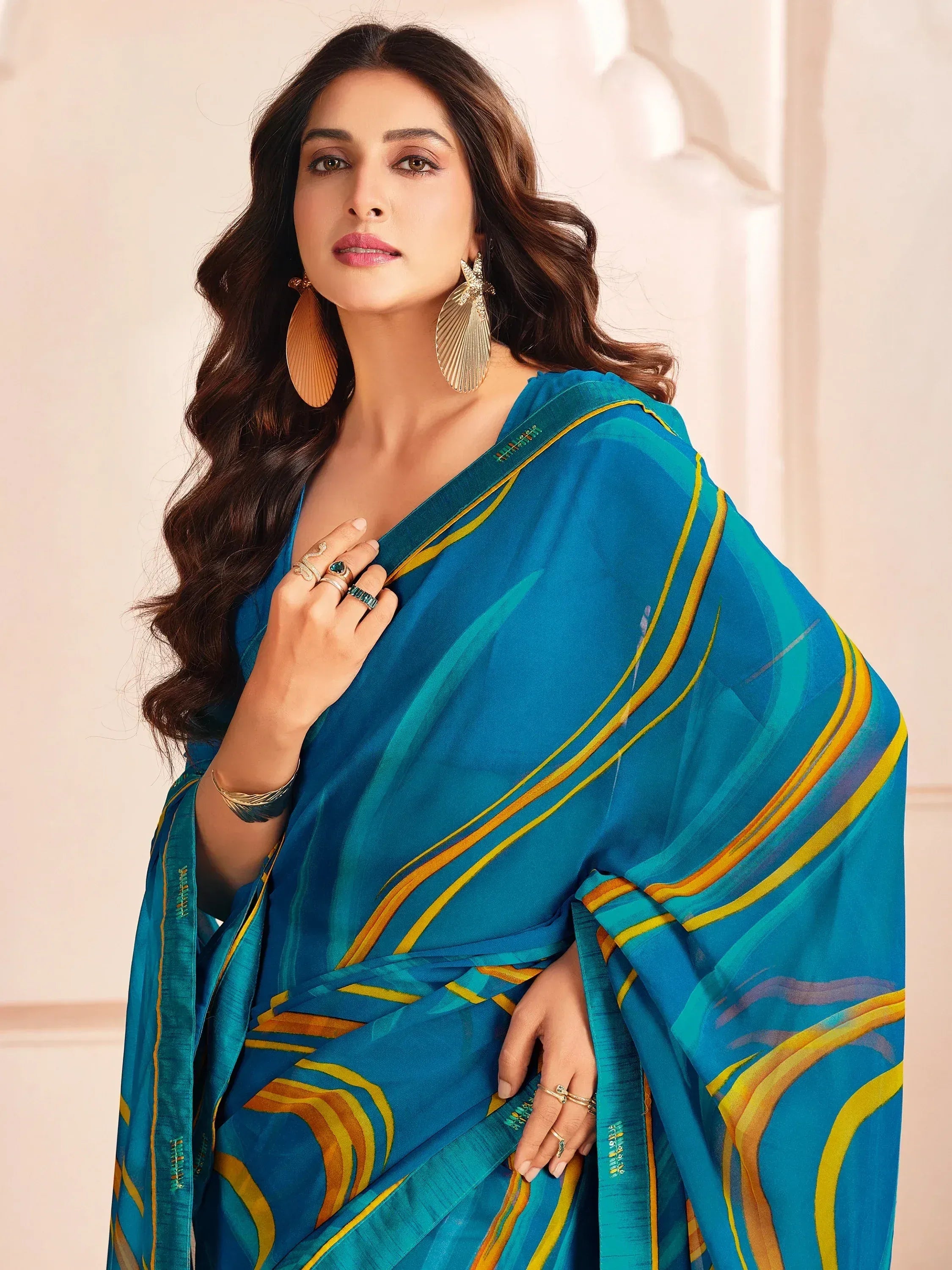 Woman in blue and gold printed saree with statement earrings, Indian ethnic wear