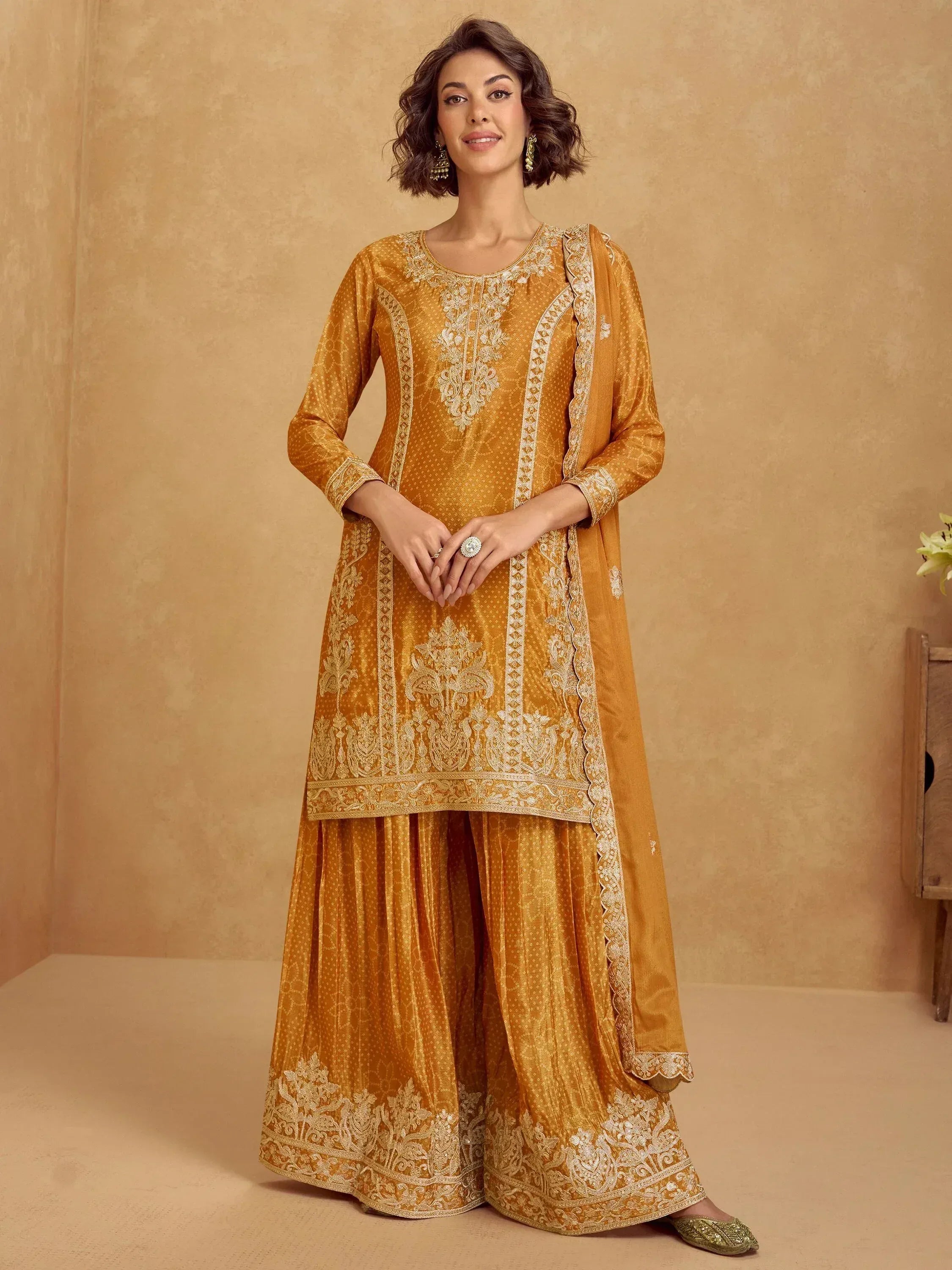 Mustard yellow embroidered palazzo suit with intricate gold detailing, perfect for festive occasions.