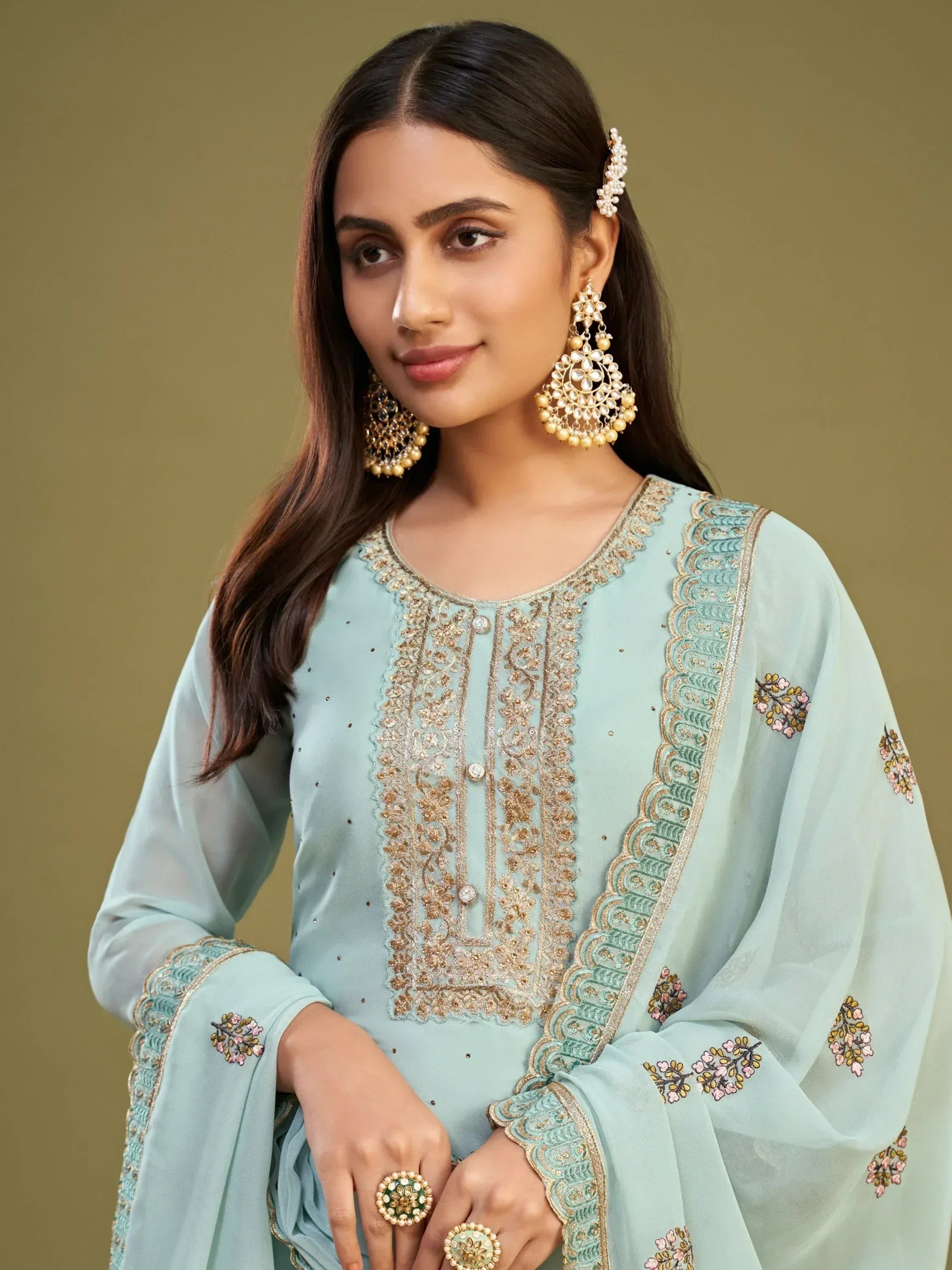 Mint green embroidered salwar kameez with gold detailing, floral motifs, and matching jewelry for ethnic wear