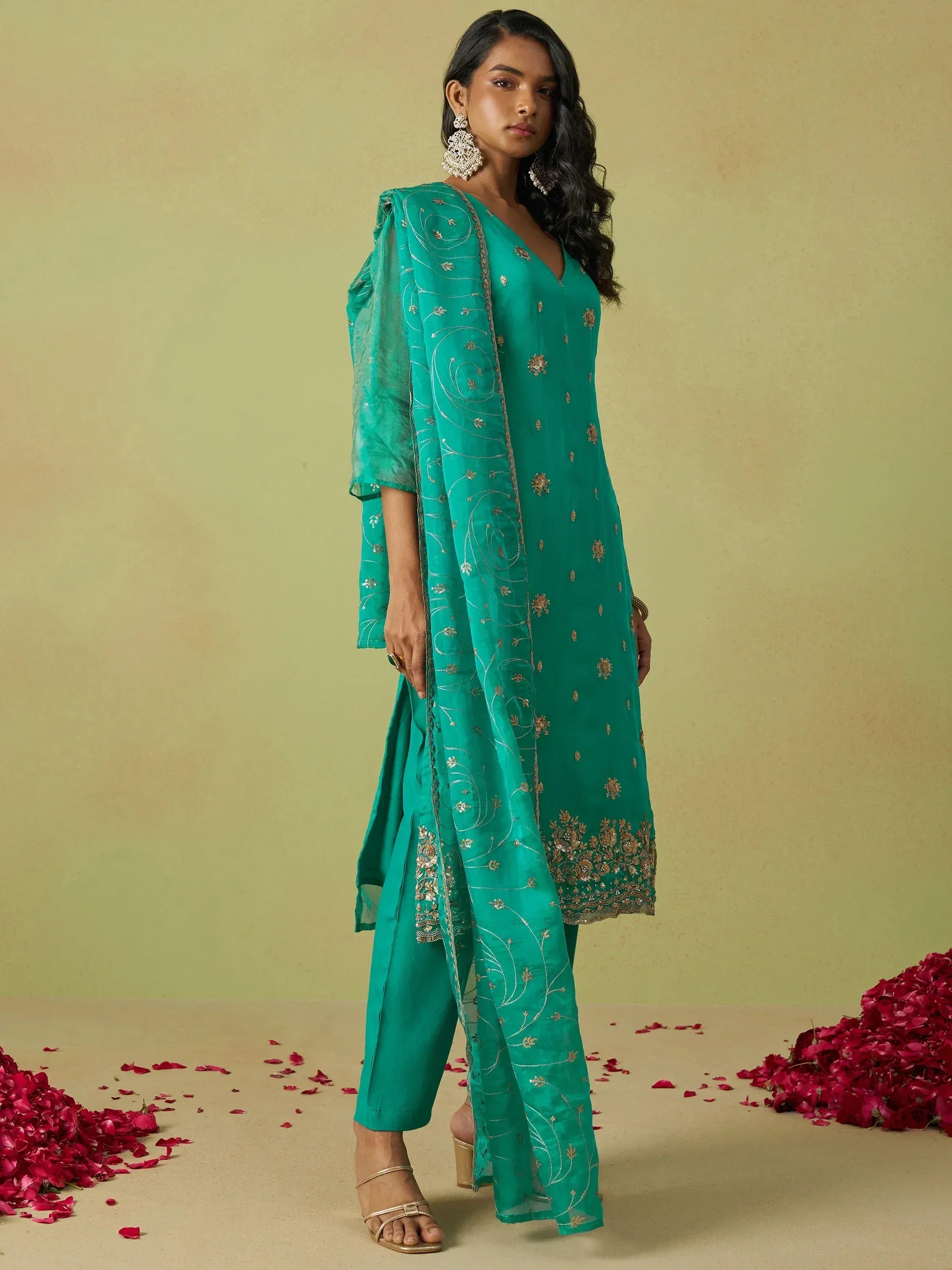 Emerald green embroidered salwar kameez with gold detailing and floral accents