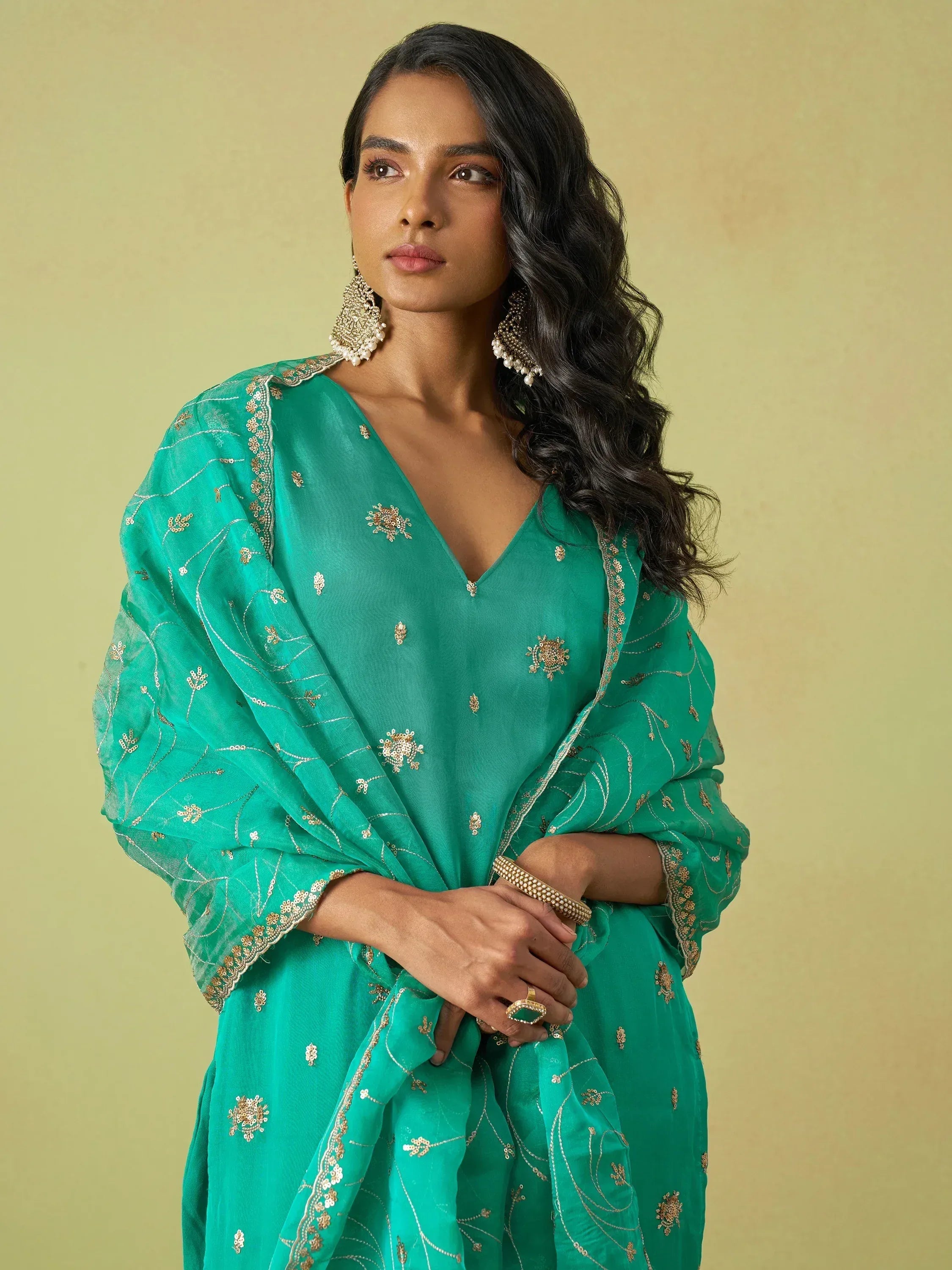 Emerald green embroidered ethnic gown with gold detailing and statement earrings