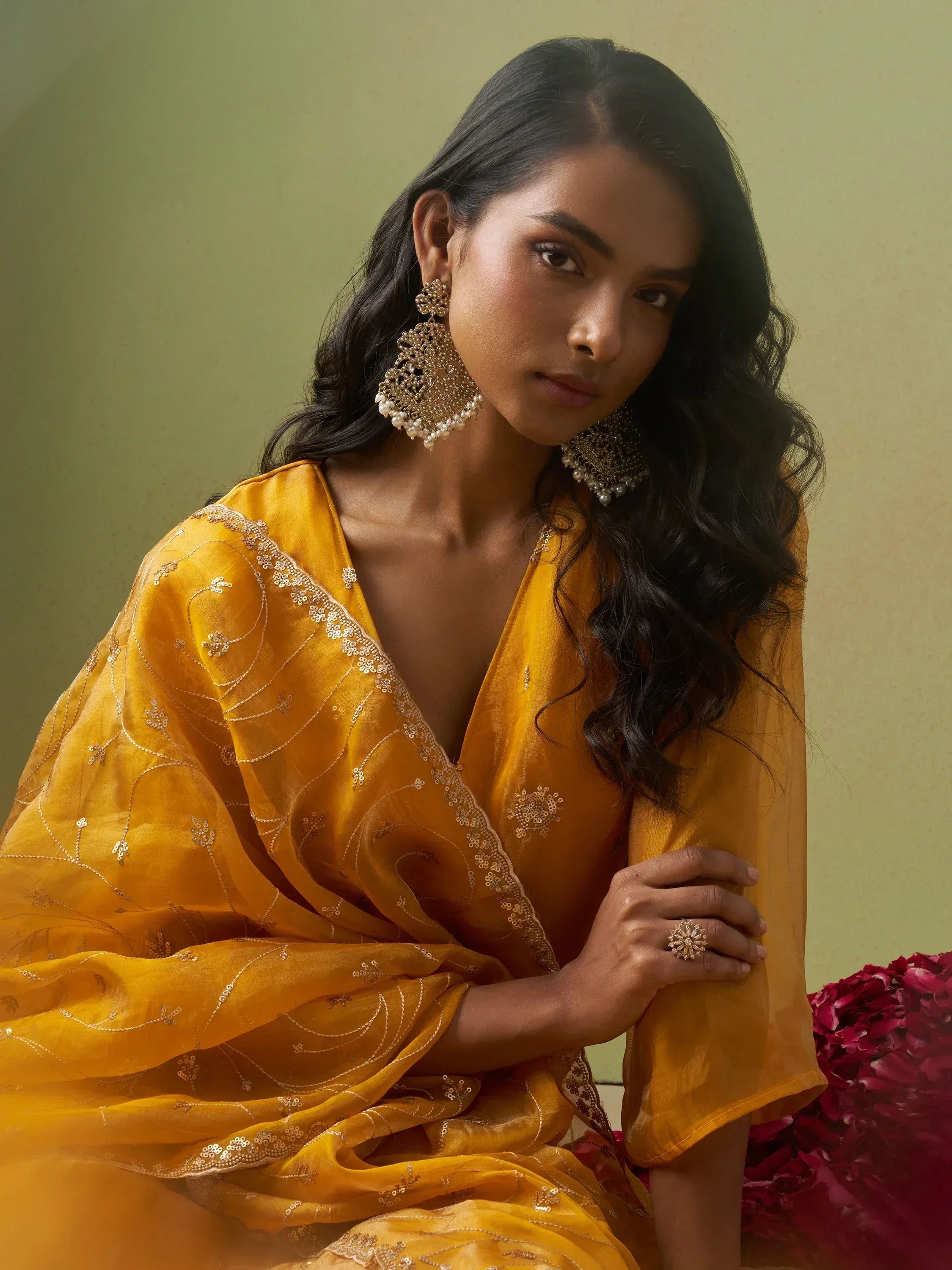 Woman in mustard yellow embroidered ethnic gown with gold jewelry, perfect for Indian festive occasions