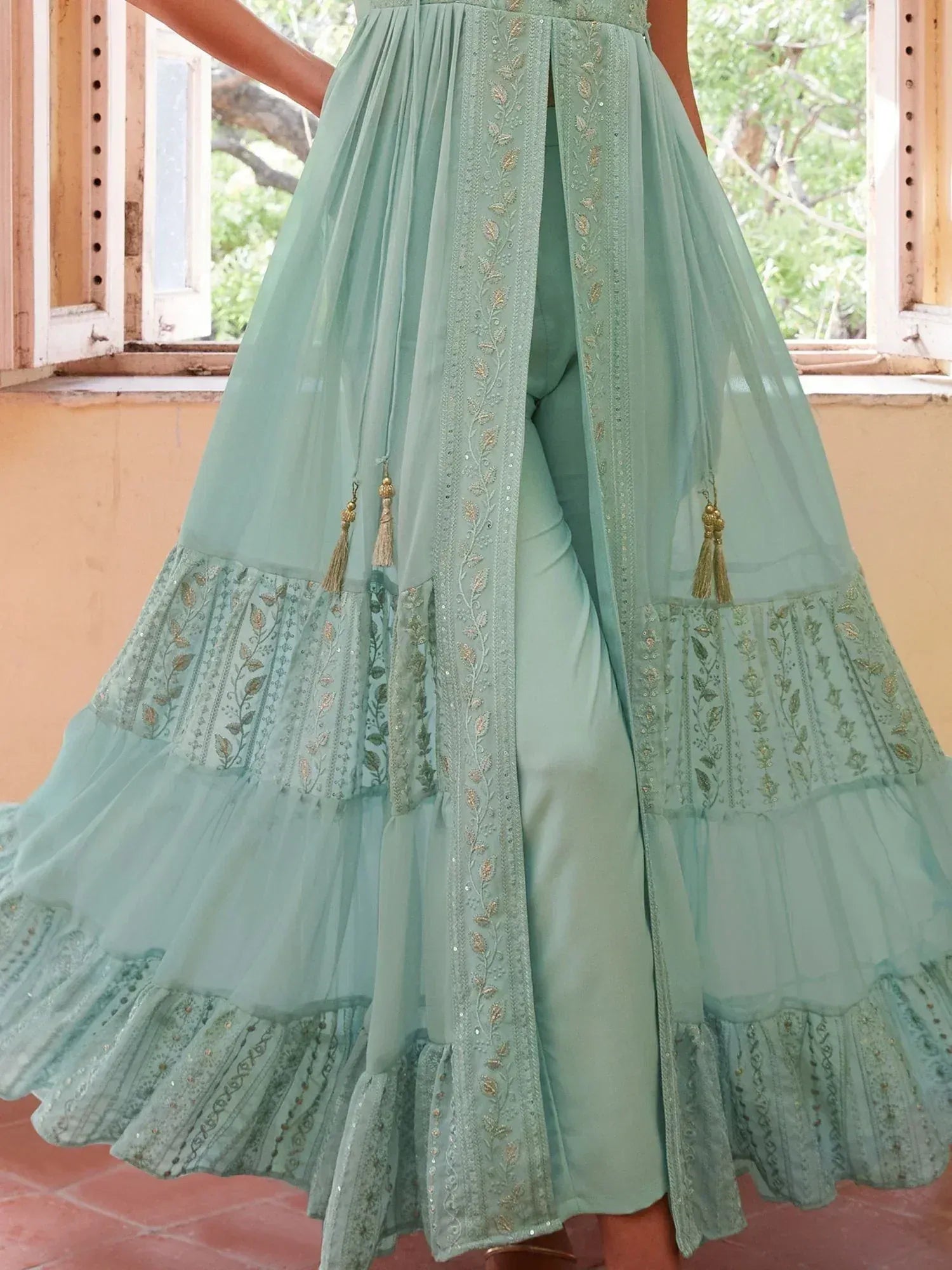 Mint green embroidered sharara with tassels, layered skirt, and gold detailing for Indian ethnic wear