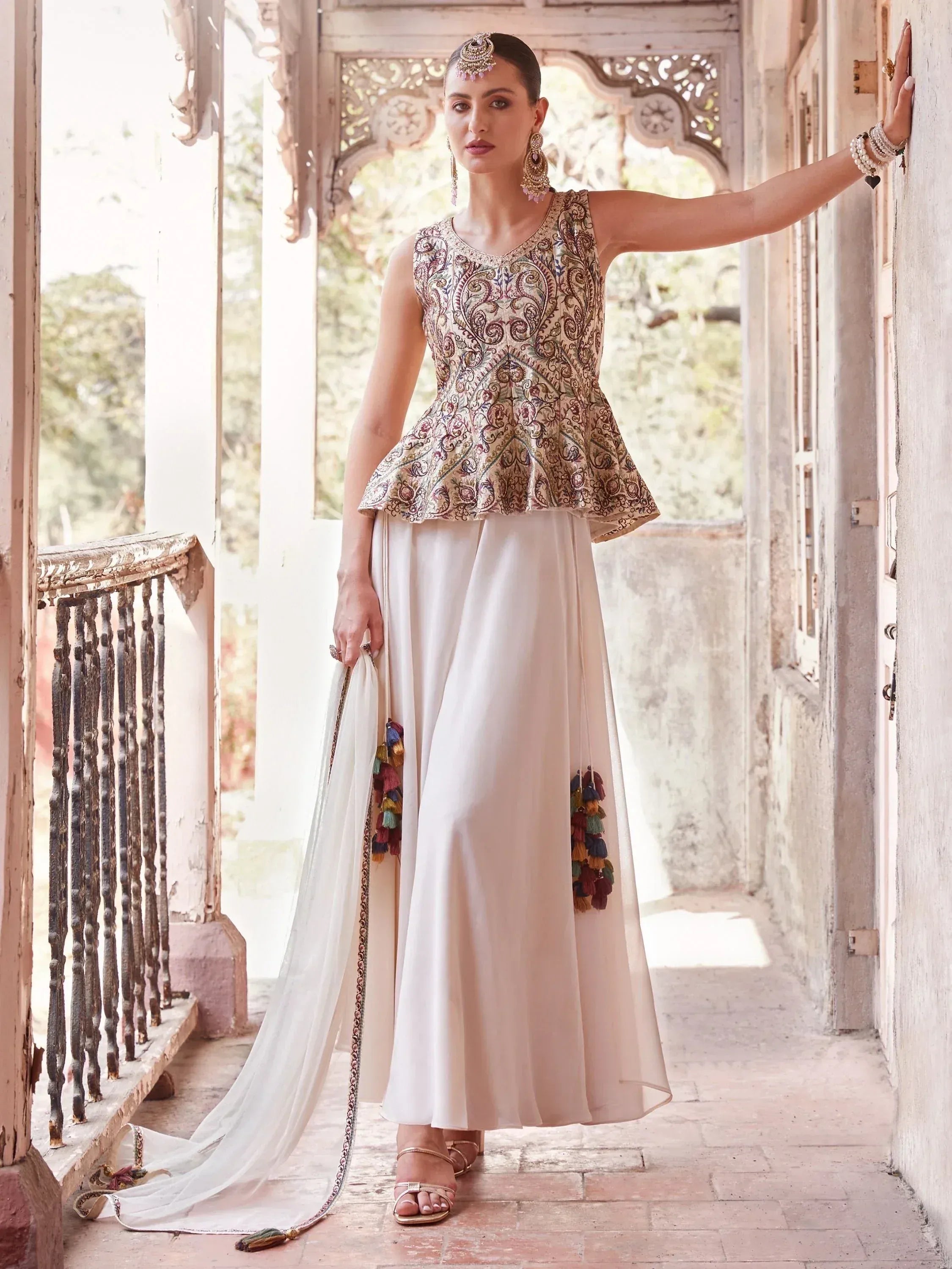 Woman in embroidered peplum ethnic lehenga with dupatta and traditional jewelry