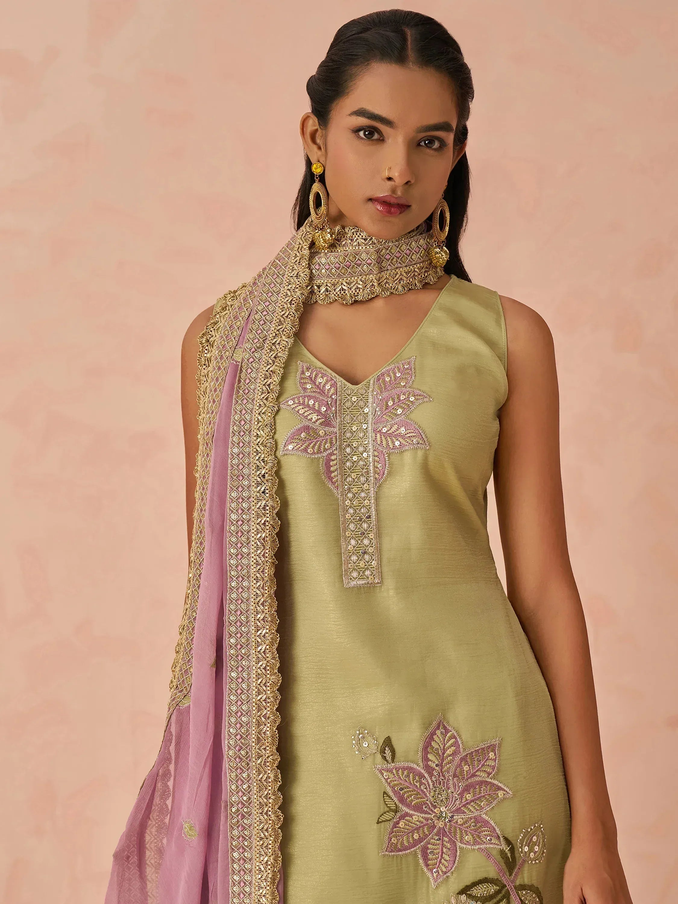 Olive green sleeveless kurta with pink floral embroidery, paired with matching dupatta and gold jewelry