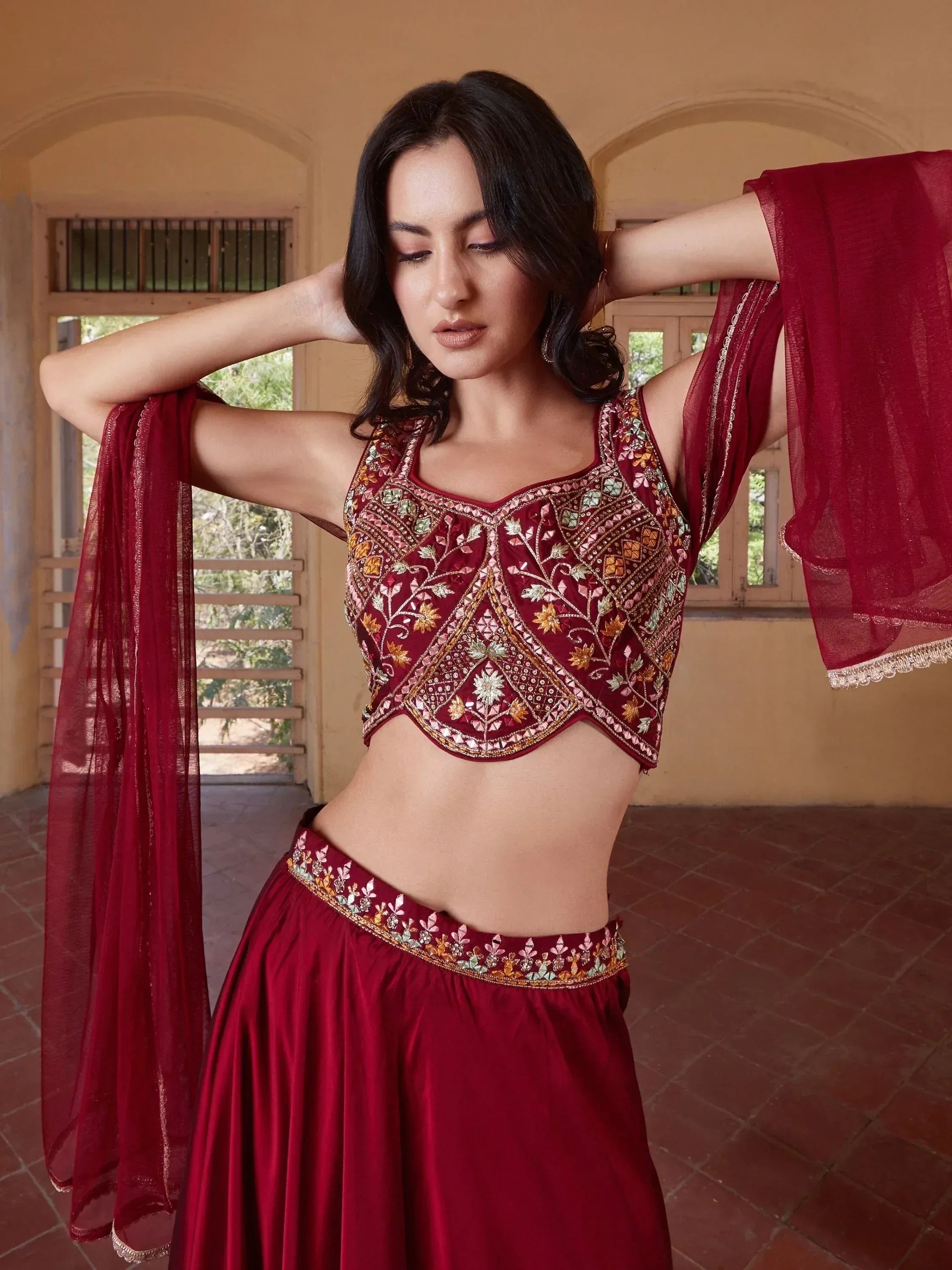 Maroon embroidered lehenga choli with floral motifs and sheer dupatta, perfect for Indian ethnic wear occasions.